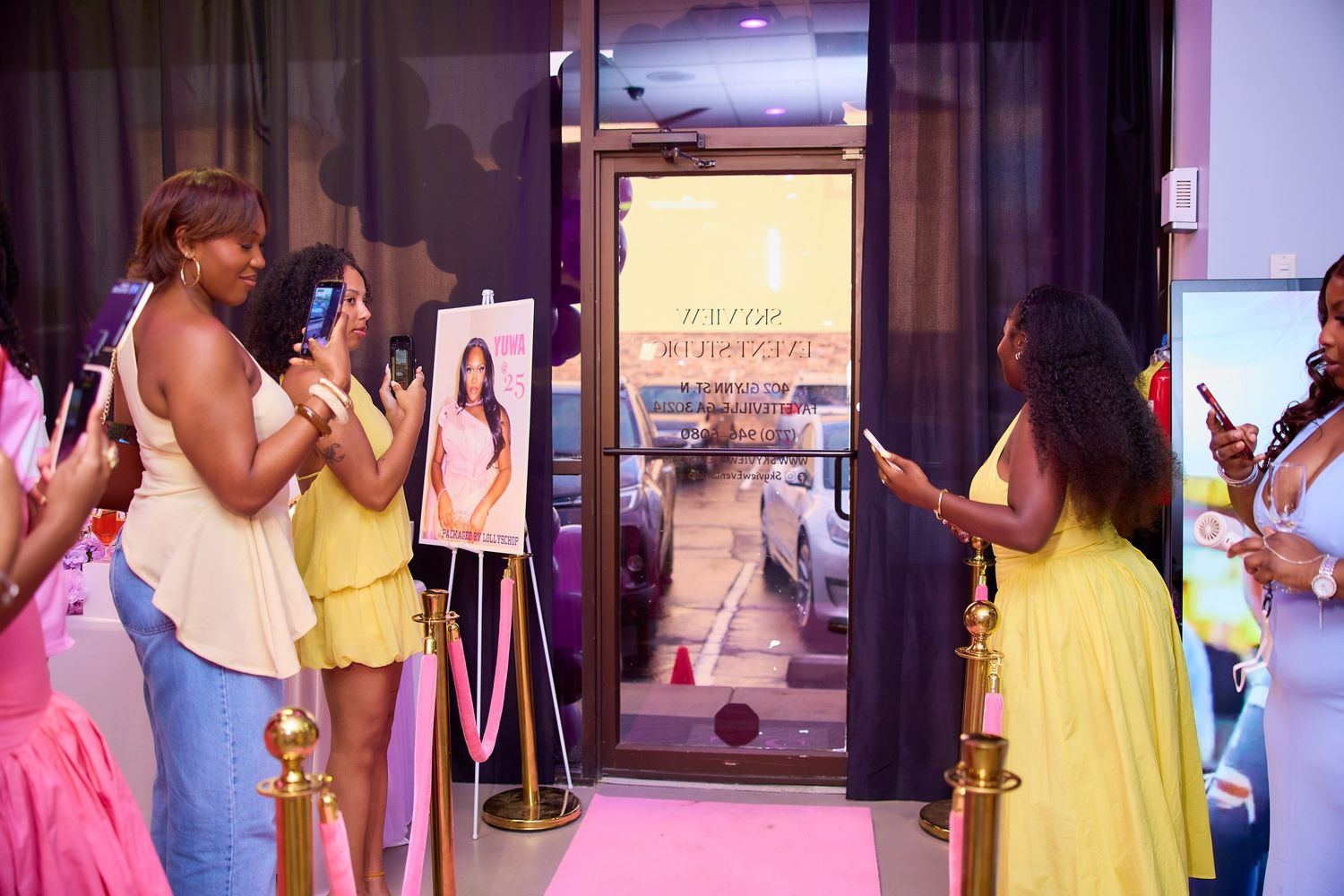 Guests photographing birthday girl entrance at pink carpet ribbon cutting ceremony.
