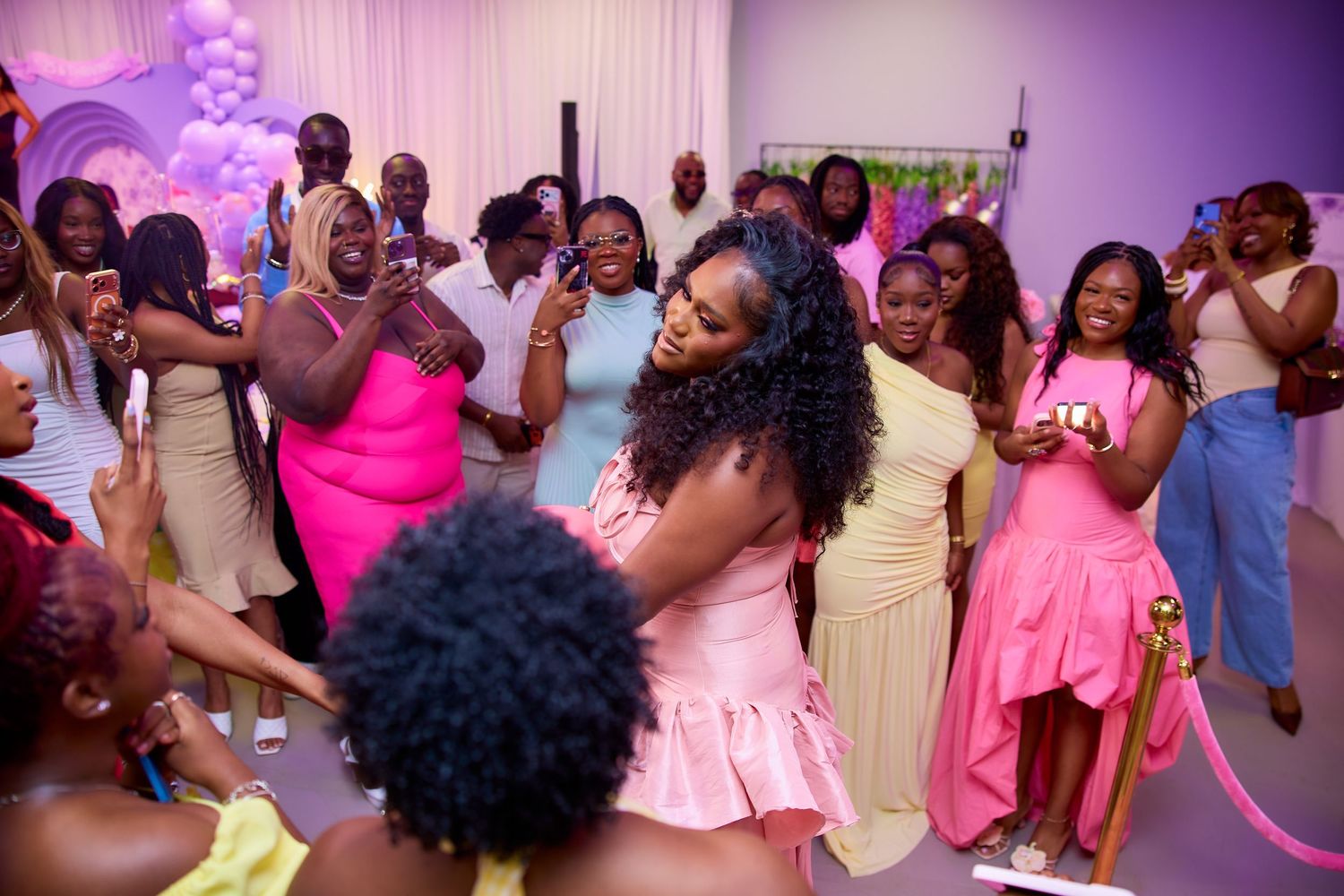 Group of women dancing and celebrating joyfully at a colorful baby shower party.