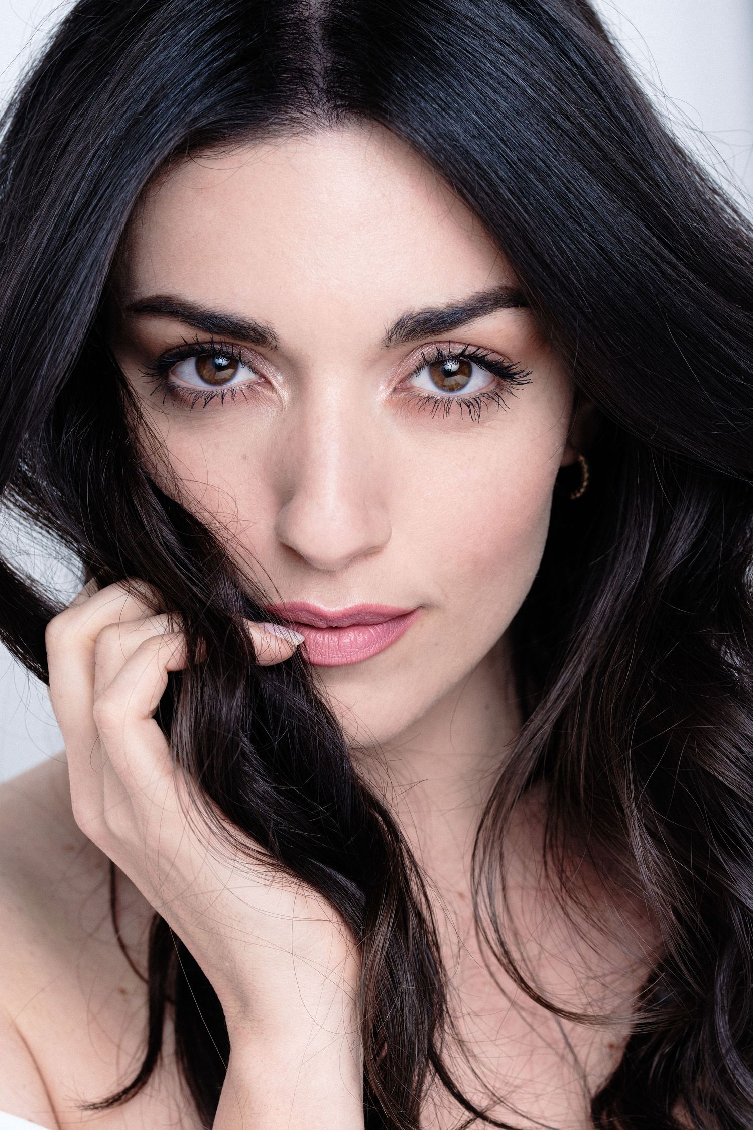 Series of close-up beauty shots with dark hair and expressive eyes against white background.