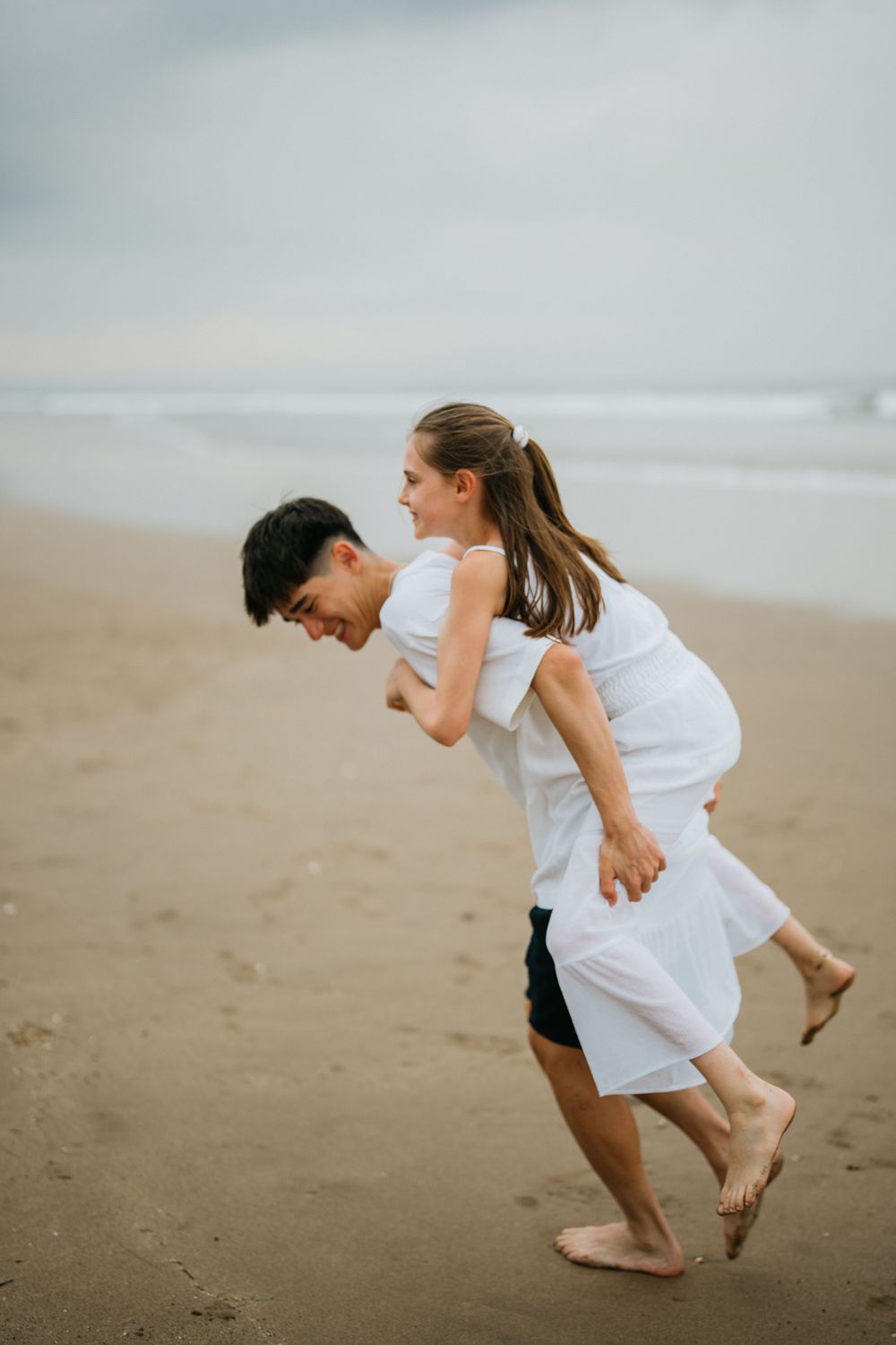 Candid laughter and fun moments captured on a misty beach.