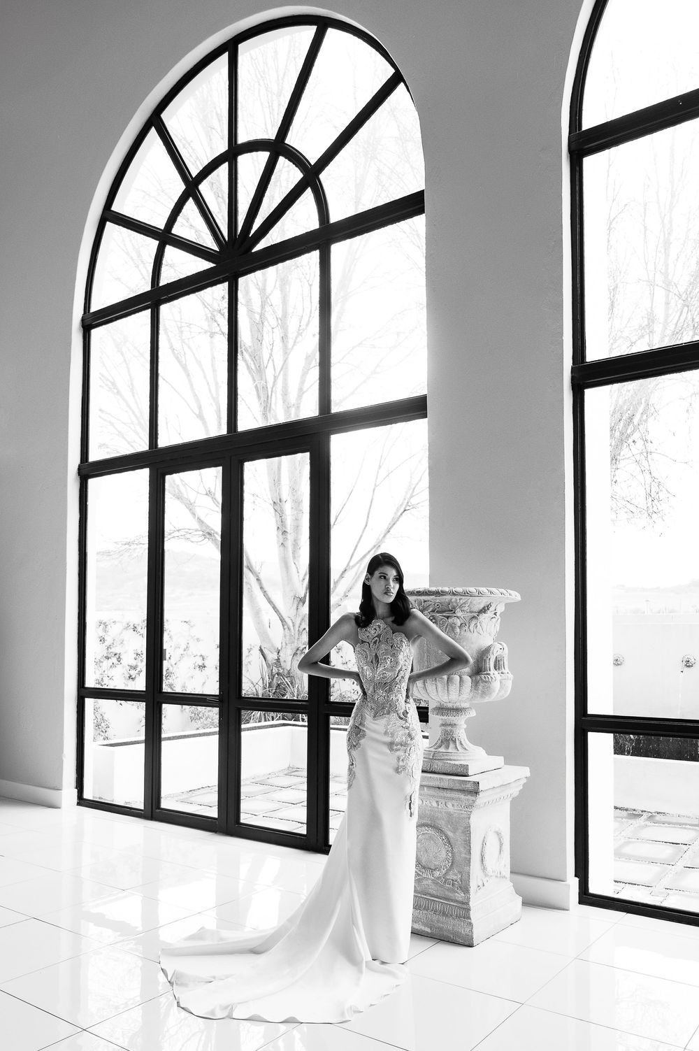 Black and white panoramic view of a bright room with dramatic arched windows and classical decor.