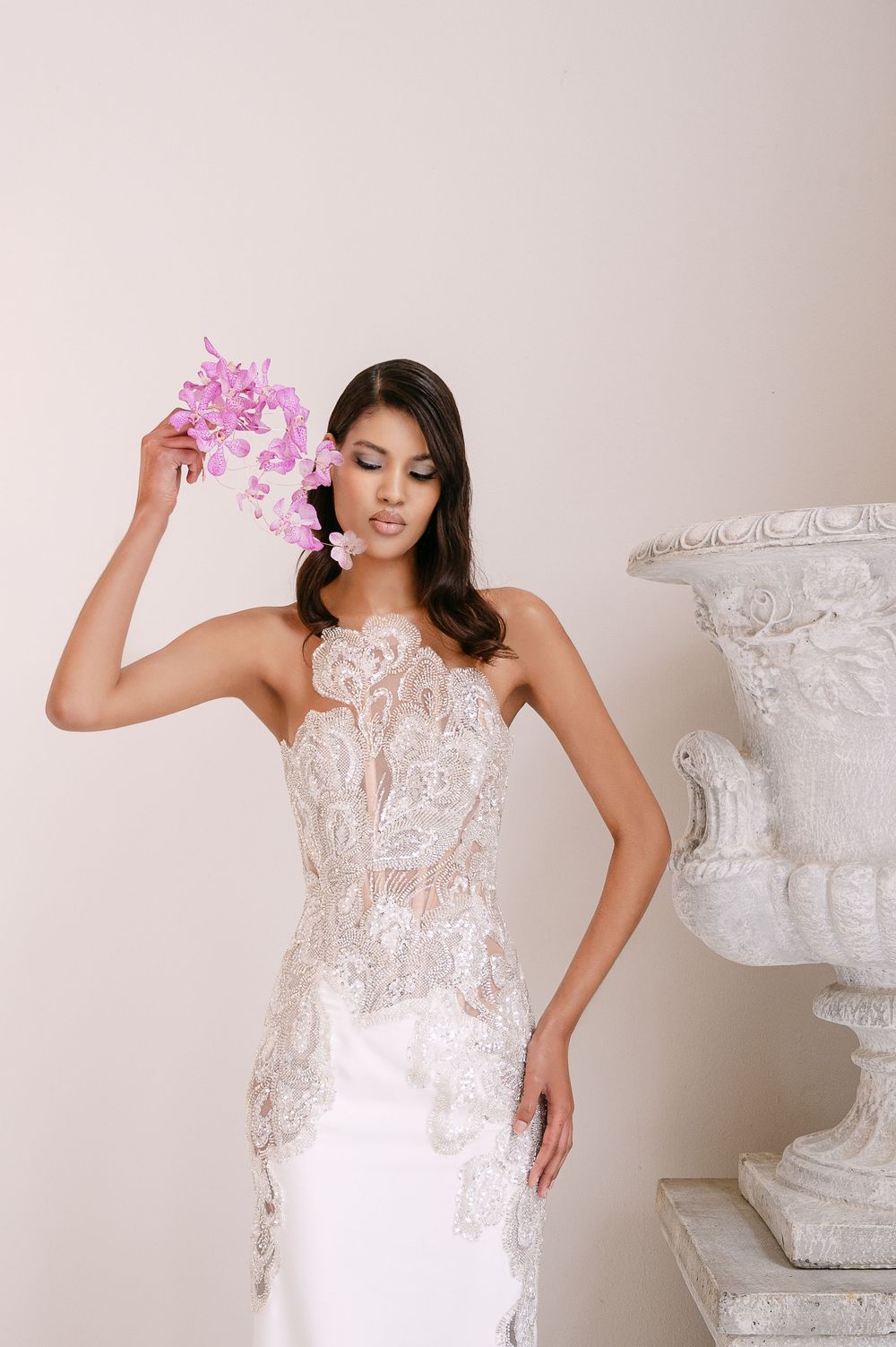 A series of romantic bridal portraits featuring a delicate lace gown and pink floral accents in a light studio setting.