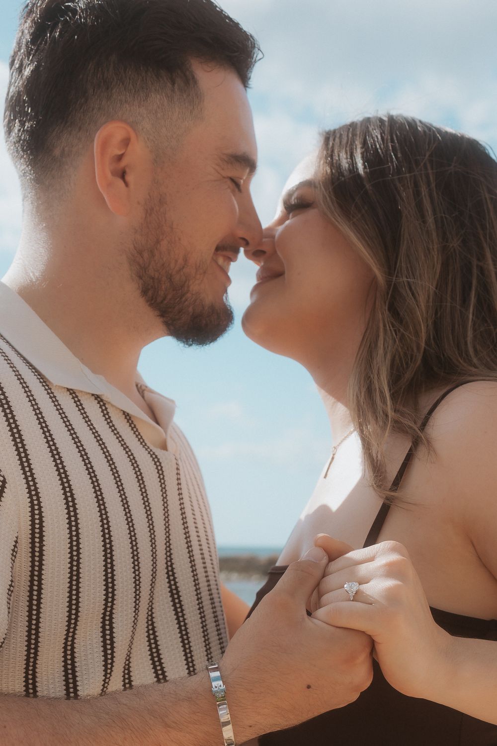 A romantic series of intimate close-up shots showing a couple in tender moments against a soft blue sky background.