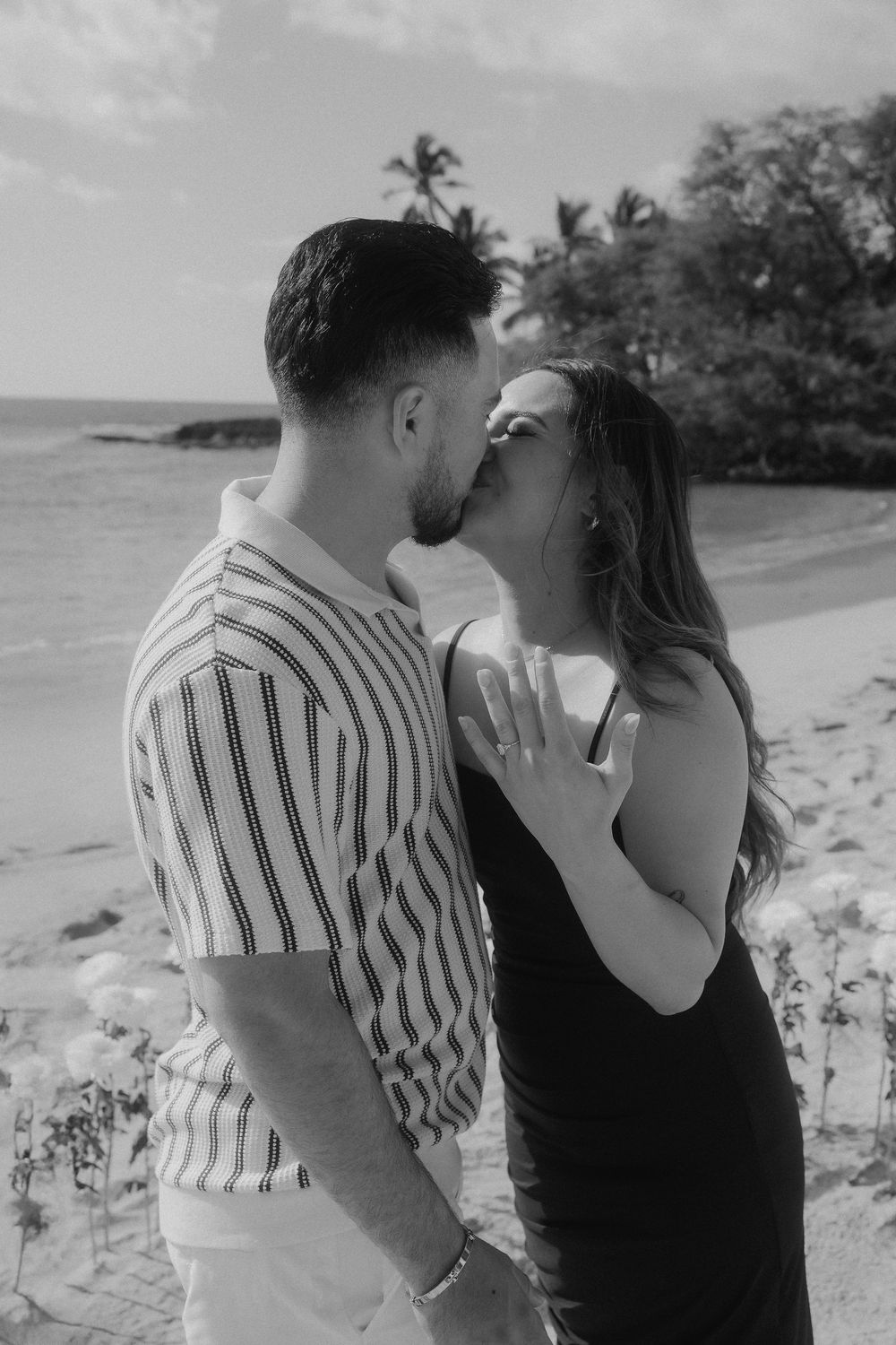 Black and white beach portraits capturing intimate moments between a couple against a tropical backdrop.