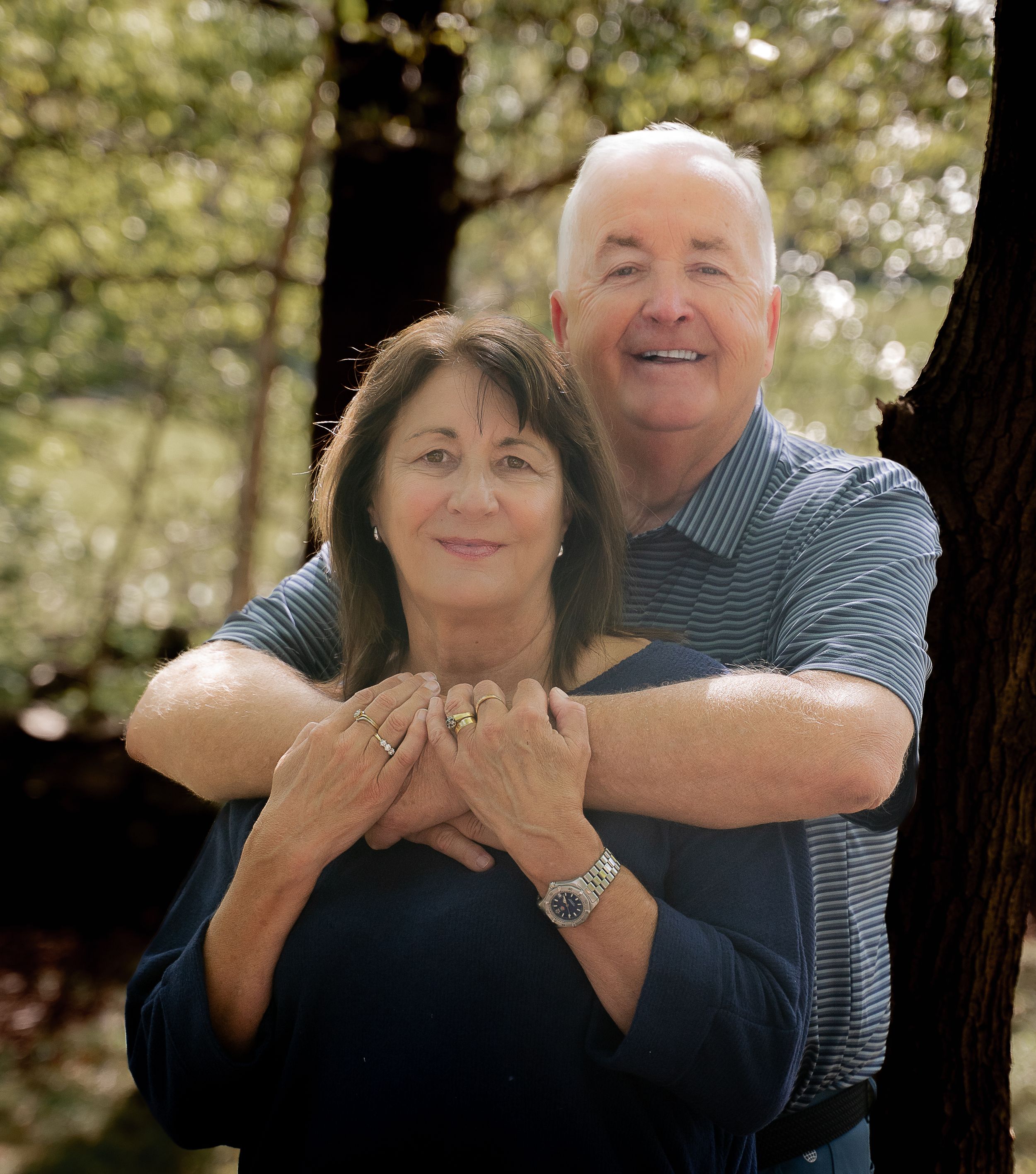 A couple embraces and laughs together in a series of candid outdoor portrait photos.