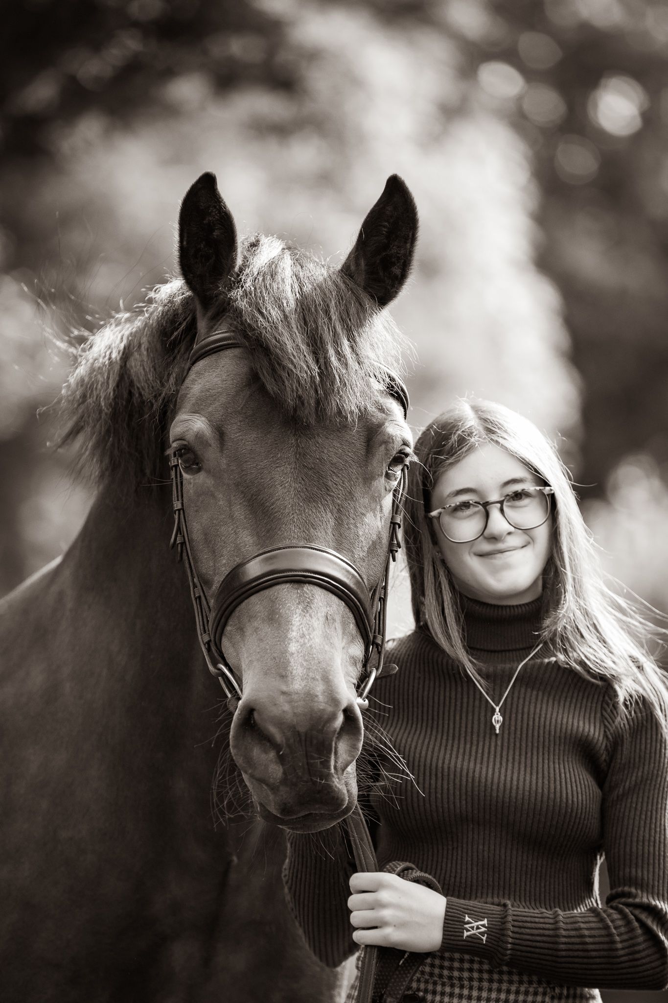 Young equestrian poses with palomino pony in a series of natural outdoor portraits showing their special bond.