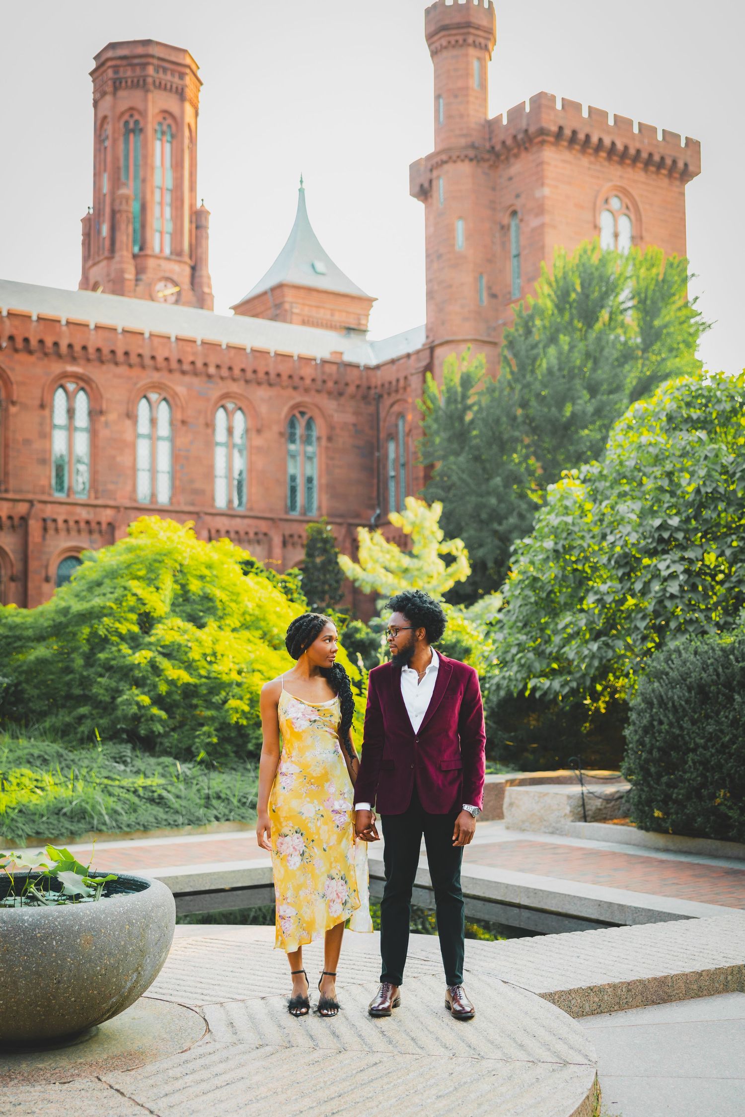 A couple path together on a brick path near the Smithsonian Castle in Washington DC for their Enid A. Haupt Garden proposal
