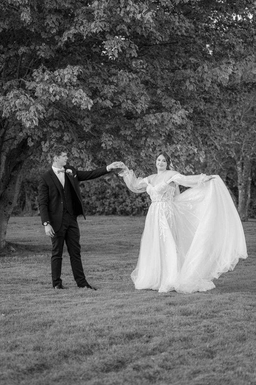 A romantic sequence of black and white wedding photos showing playful moments between a couple in a grassy field.