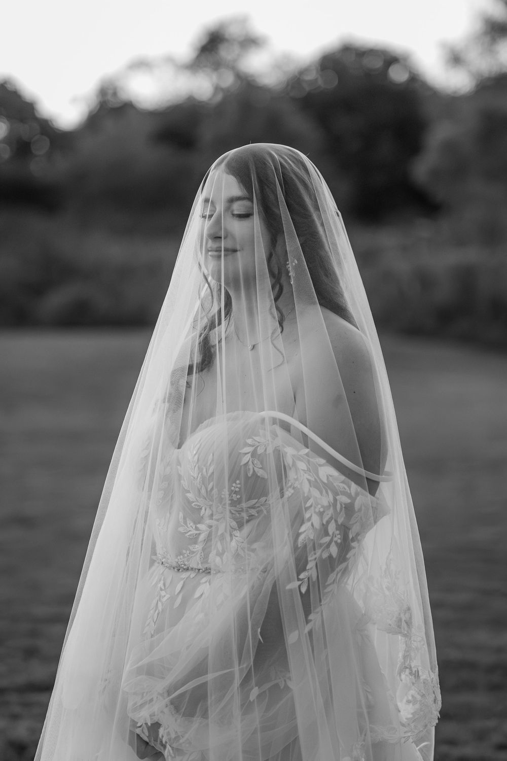 Monochromatic bridal portraits show a soft close-up of a bride wearing an elegant veil with delicate embroidery.