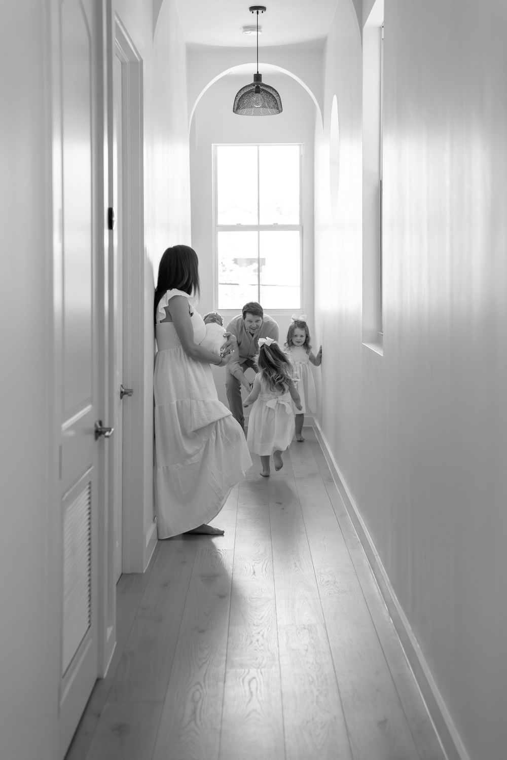 A series of black and white images showing dreamy movement in a bright white hallway.
