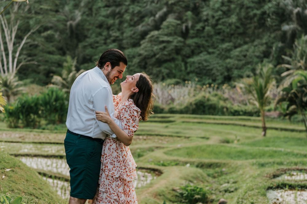 A tender embrace captured against a backdrop of rolling green hills.