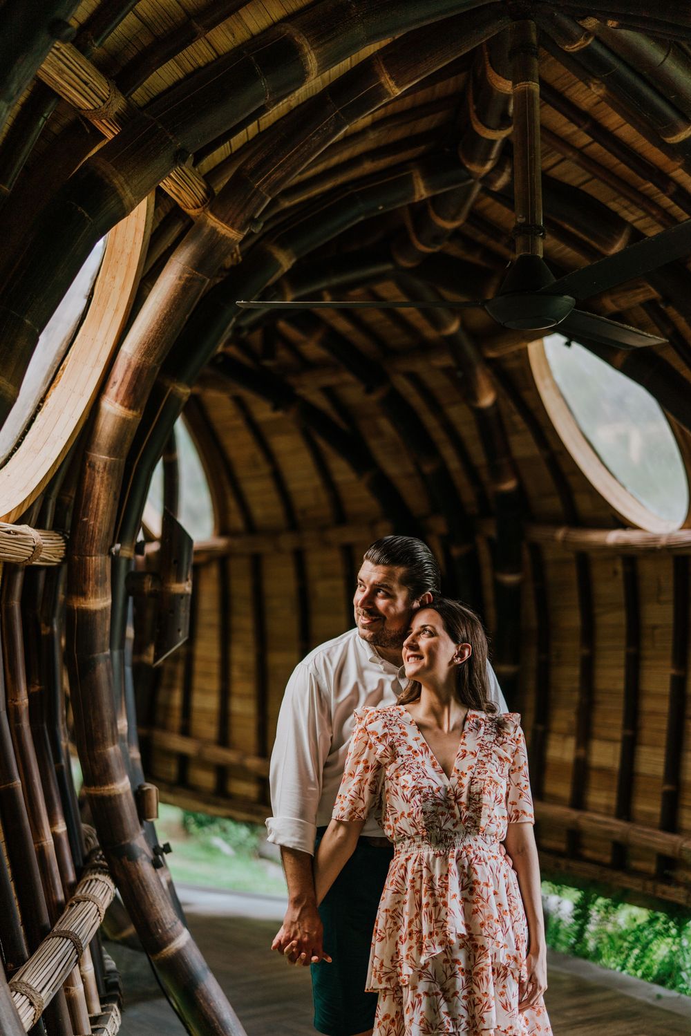 Inside view of a bamboo structure with curved beams and natural lighting.