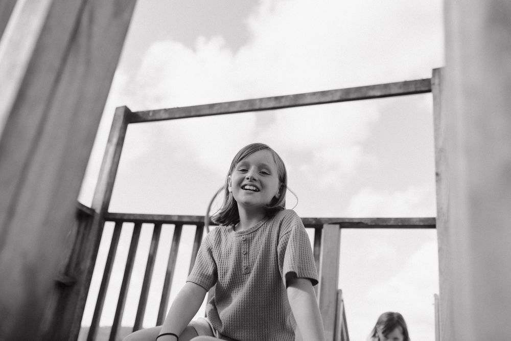 A heartwarming interaction on a rustic porch swing with natural light filtering through.