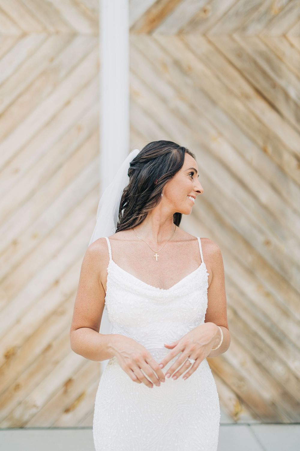 Elegant bridal portraits against chevron wood wall showcasing lace gown details.