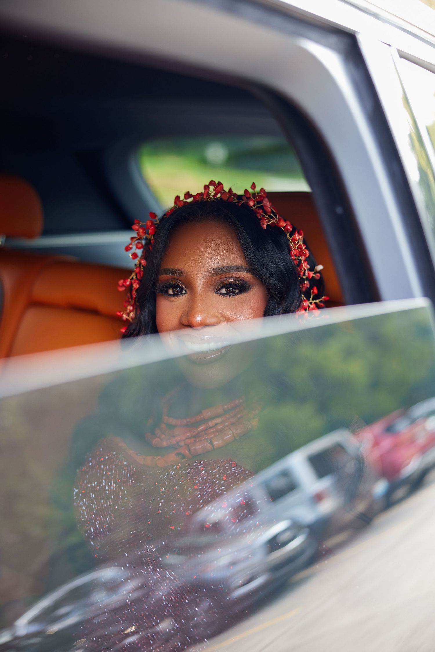 A decorated window view showing glimpses of elegant wedding attire and floral accessories through a car window.