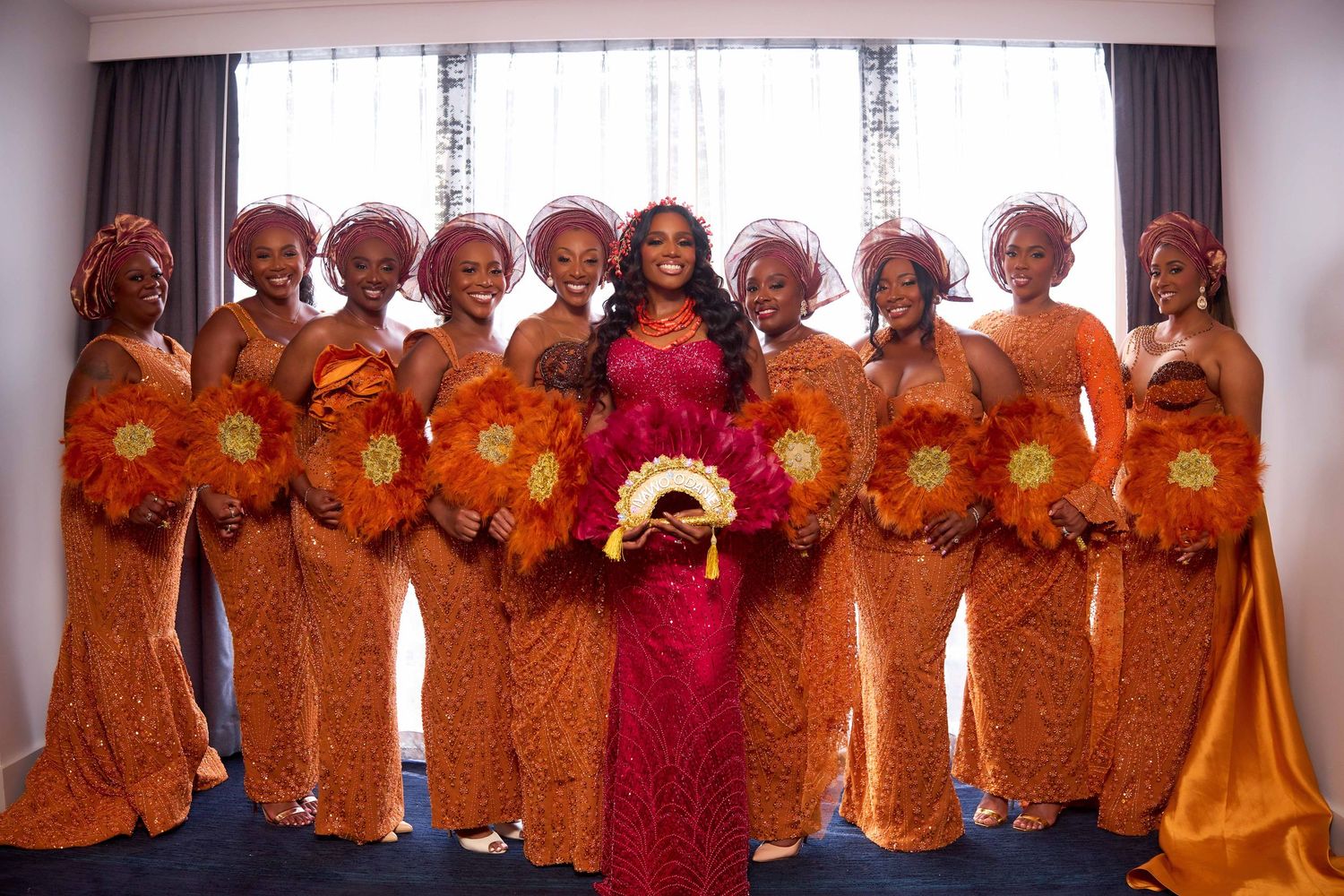 Group of people wearing traditional orange outfits gather for a celebration.