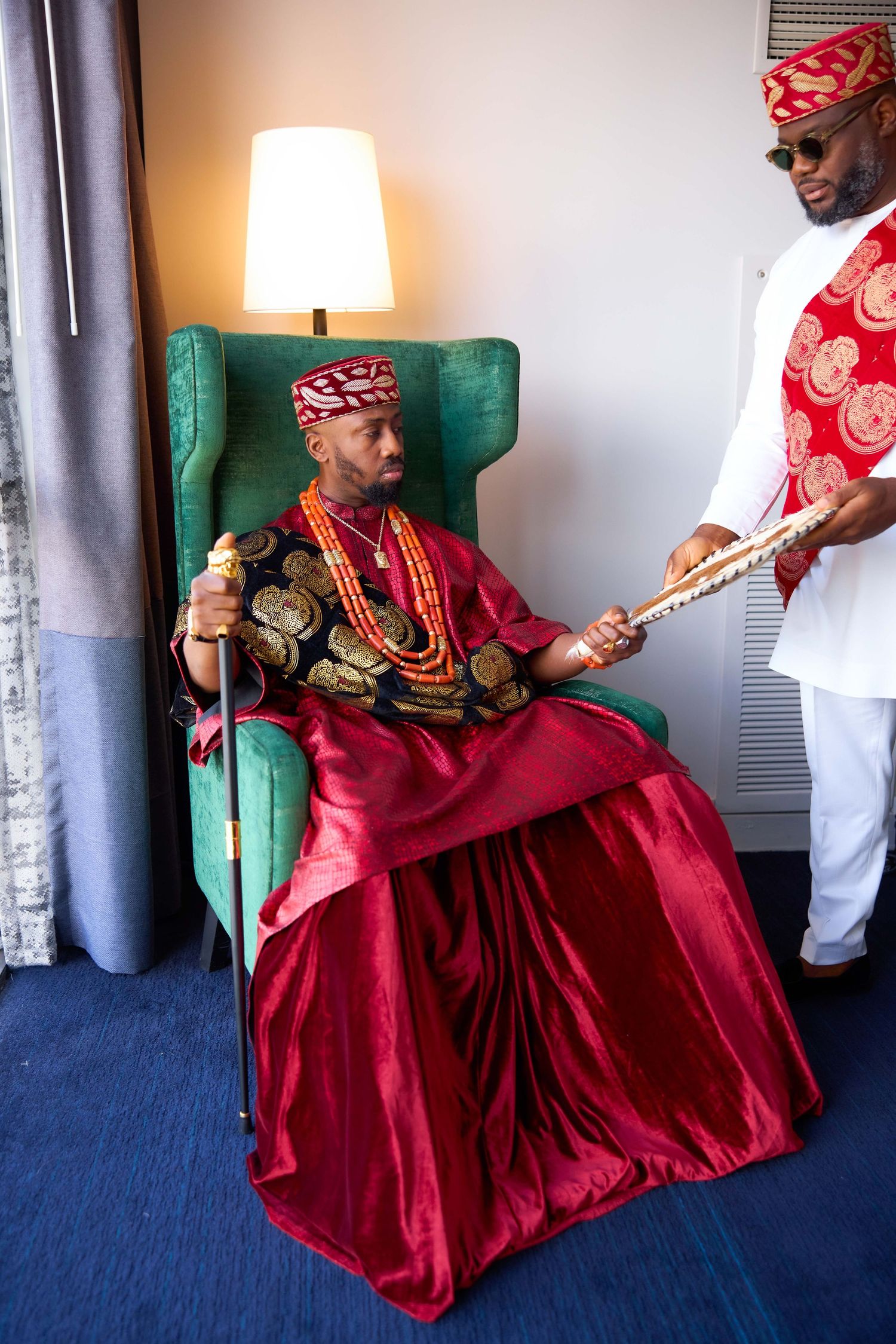 Four sequential shots show someone in a red traditional dress sitting in a green armchair while playing a guitar.