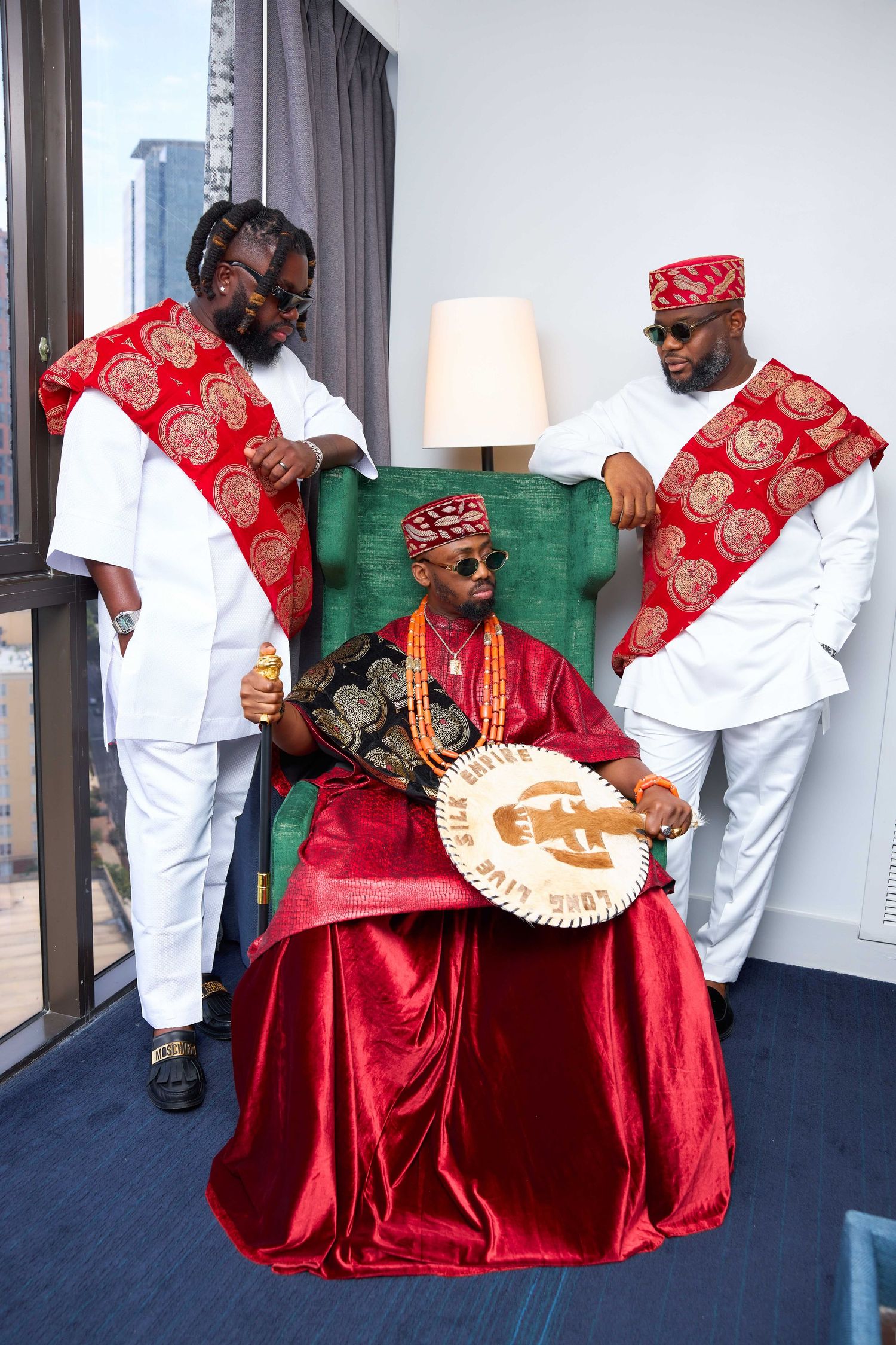 A sequence of red velvet gowns and white shirts shown in five progressive poses against a grey wall.