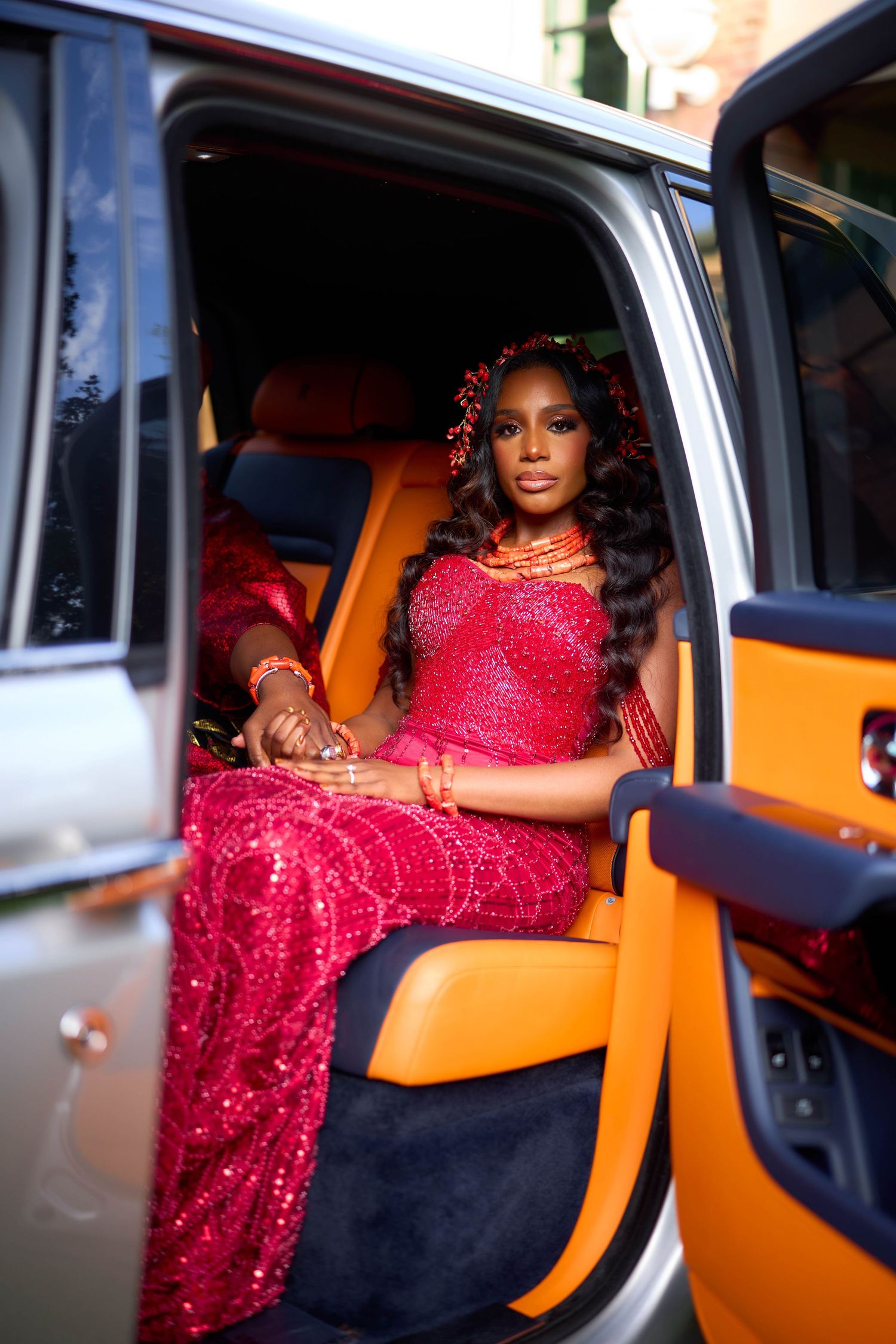 Series of shots showing a red sequin dress in an orange and silver vehicle interior.