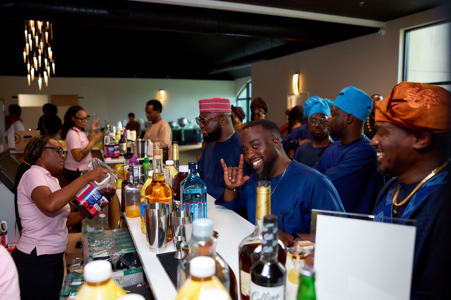 A lively bar scene shows patrons enjoying drinks and socializing under warm lighting in a bustling establishment.