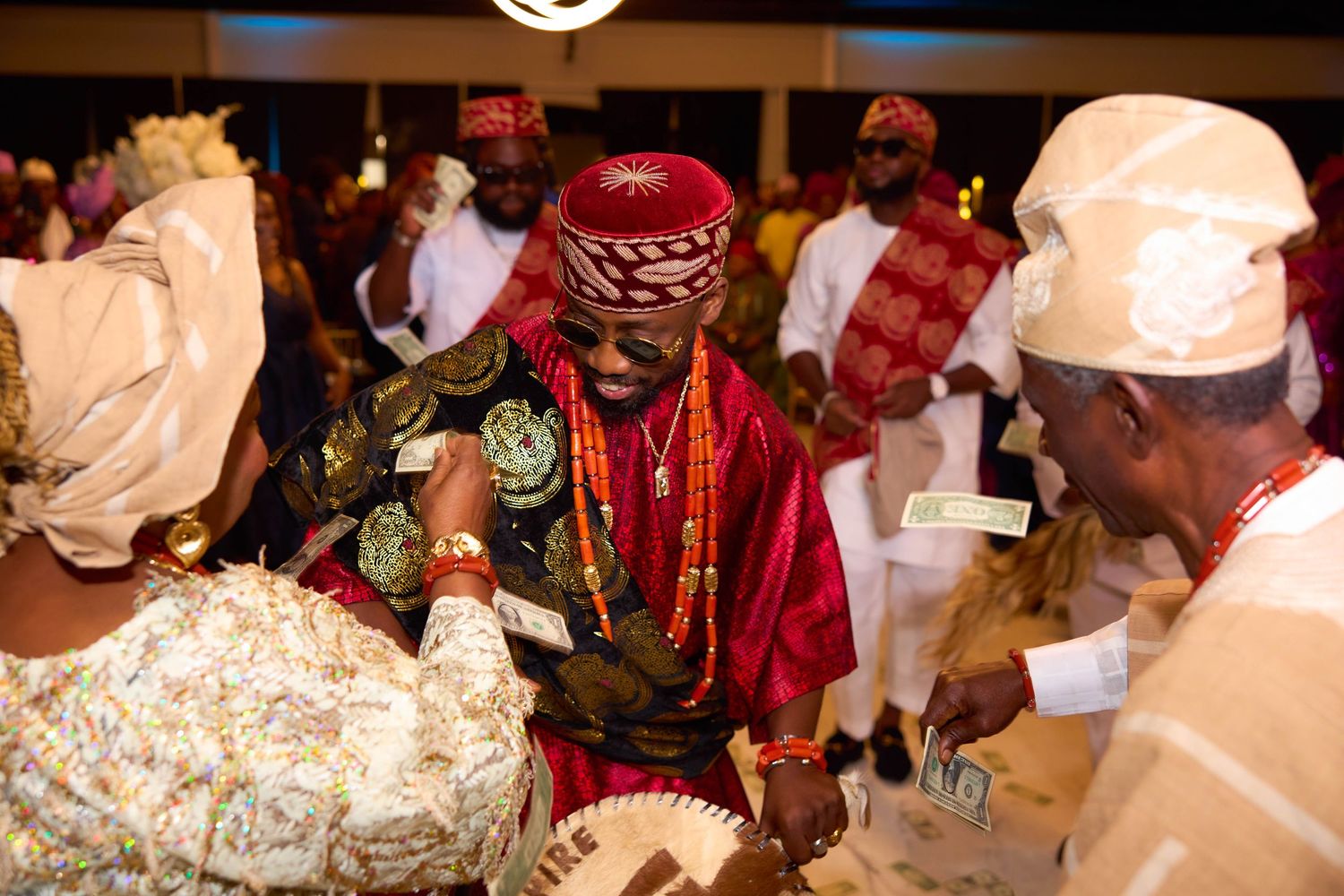 Traditional wedding ceremony with vibrant red and gold decor showcasing cultural attire and rituals.