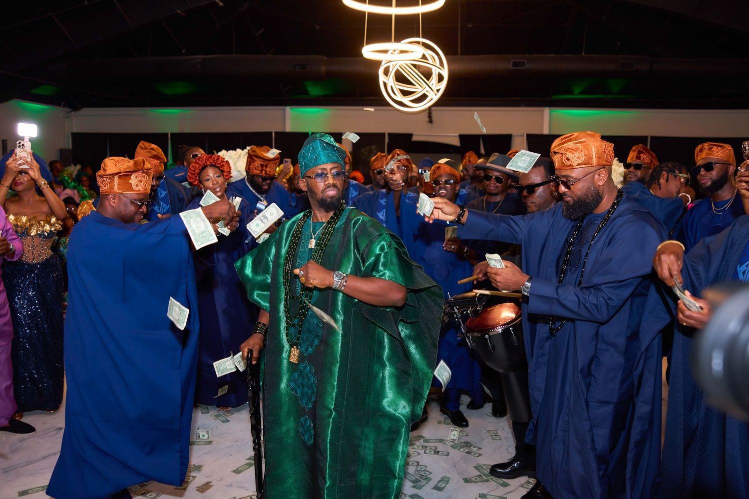 Medical staff in blue and green scrubs socialize during a professional event in a large gathering space.