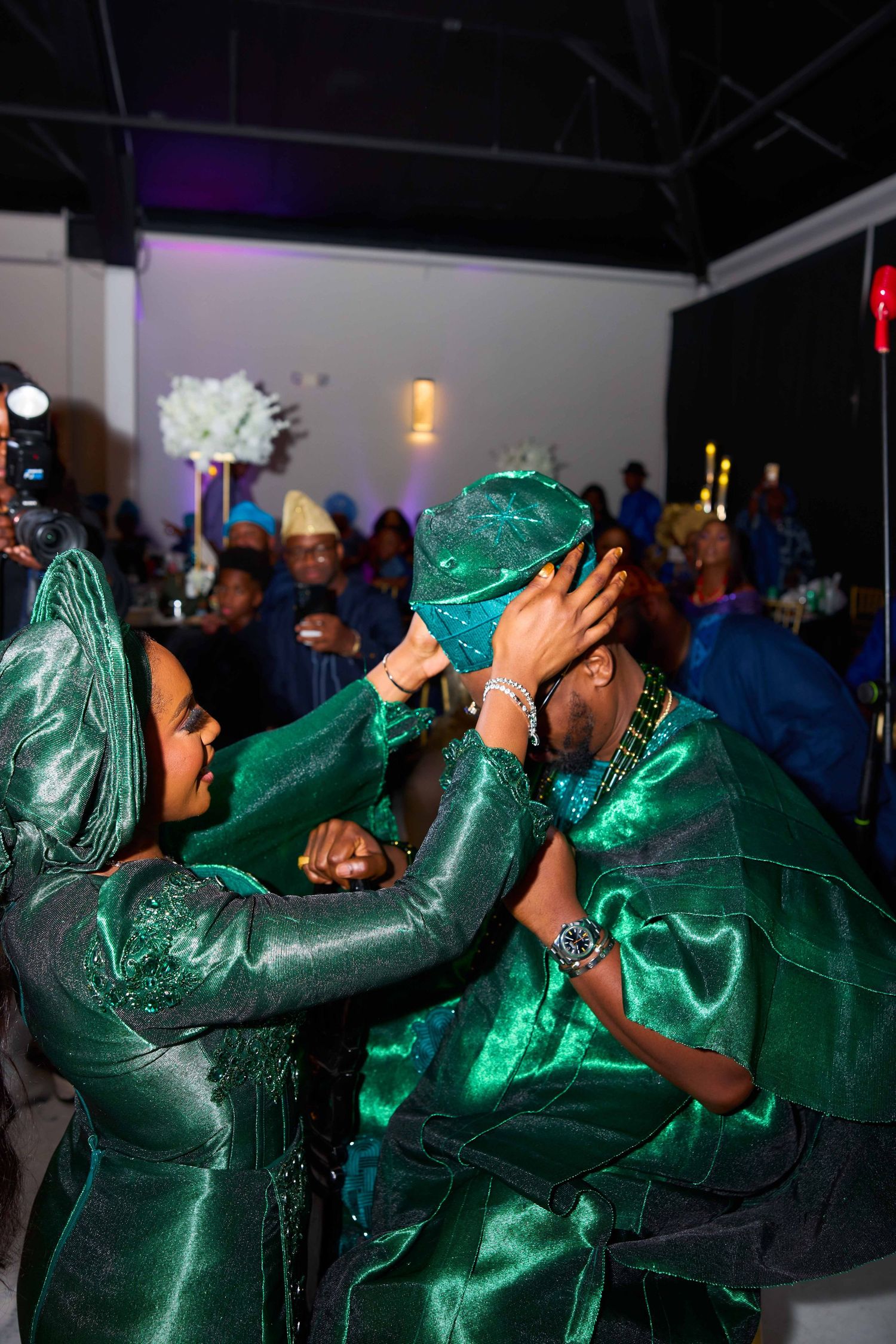 Dance performers in matching emerald green sequined outfits performing synchronized movements at an event.