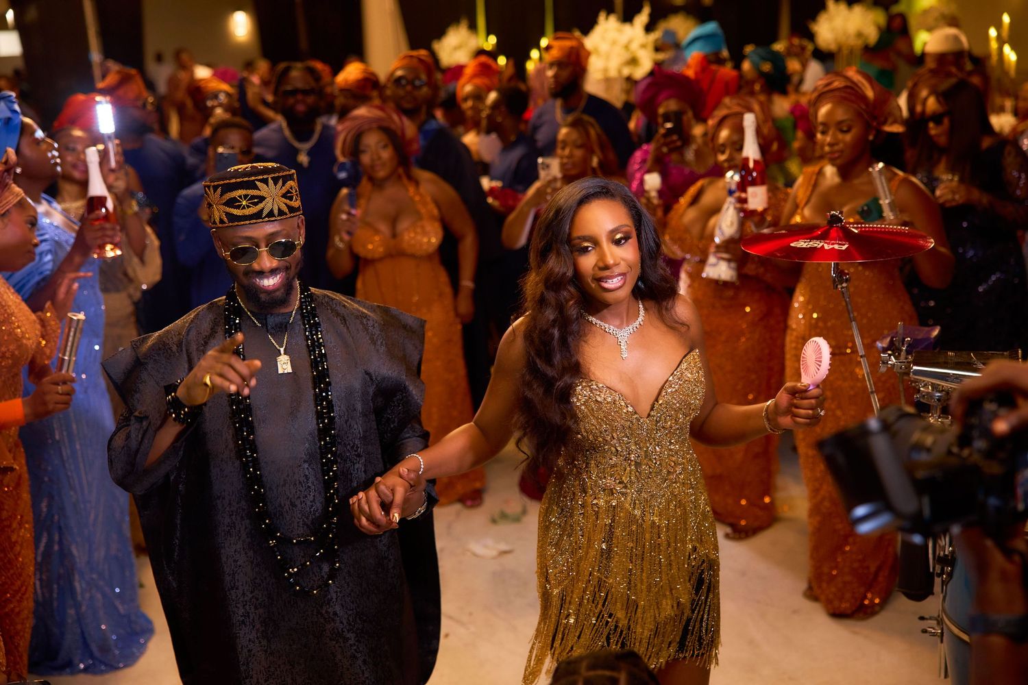 Guests dancing and celebrating at an elegant evening wedding reception with warm lighting and festive atmosphere.