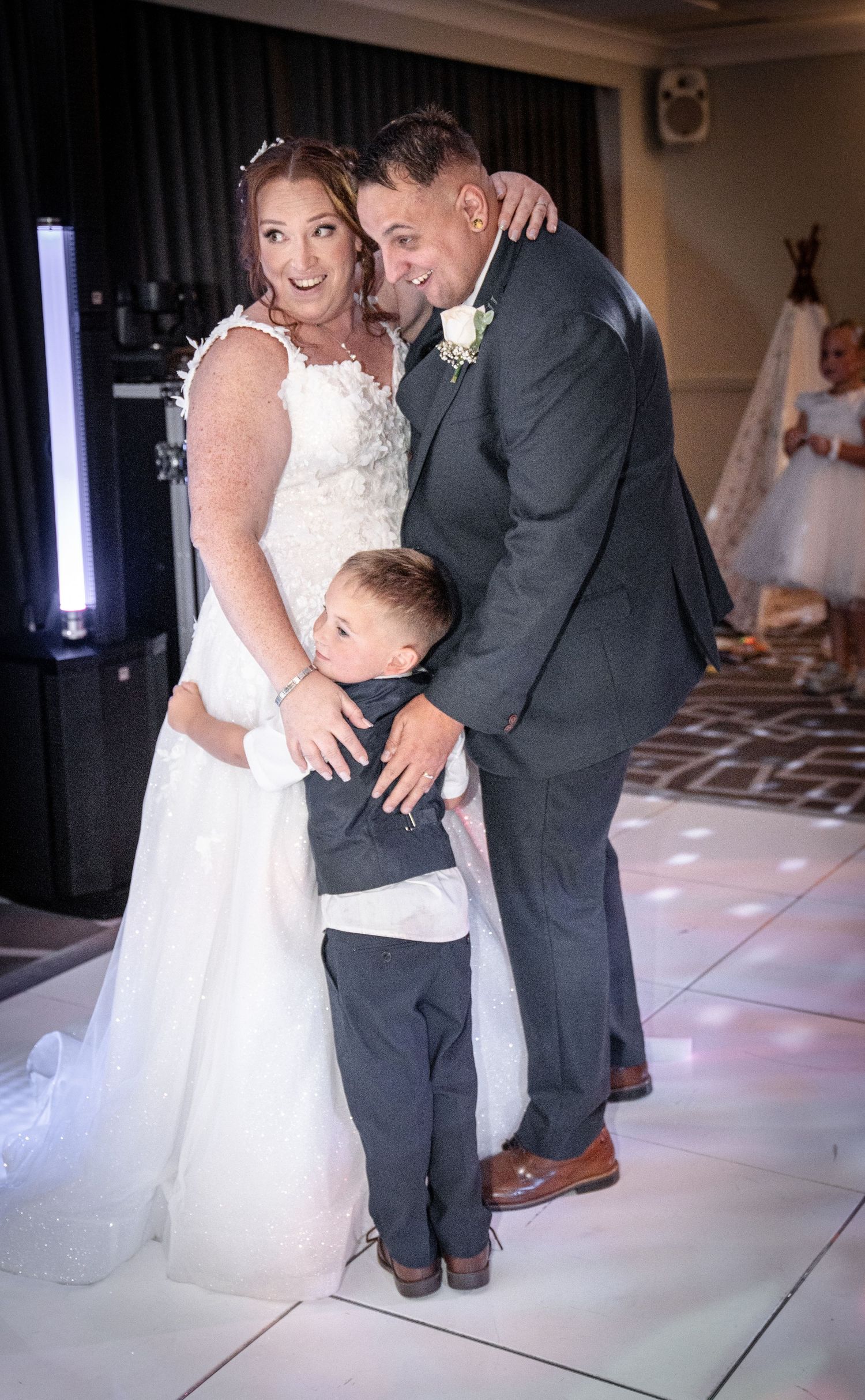 Sweet dance moments captured on an illuminated floor during a wedding celebration.