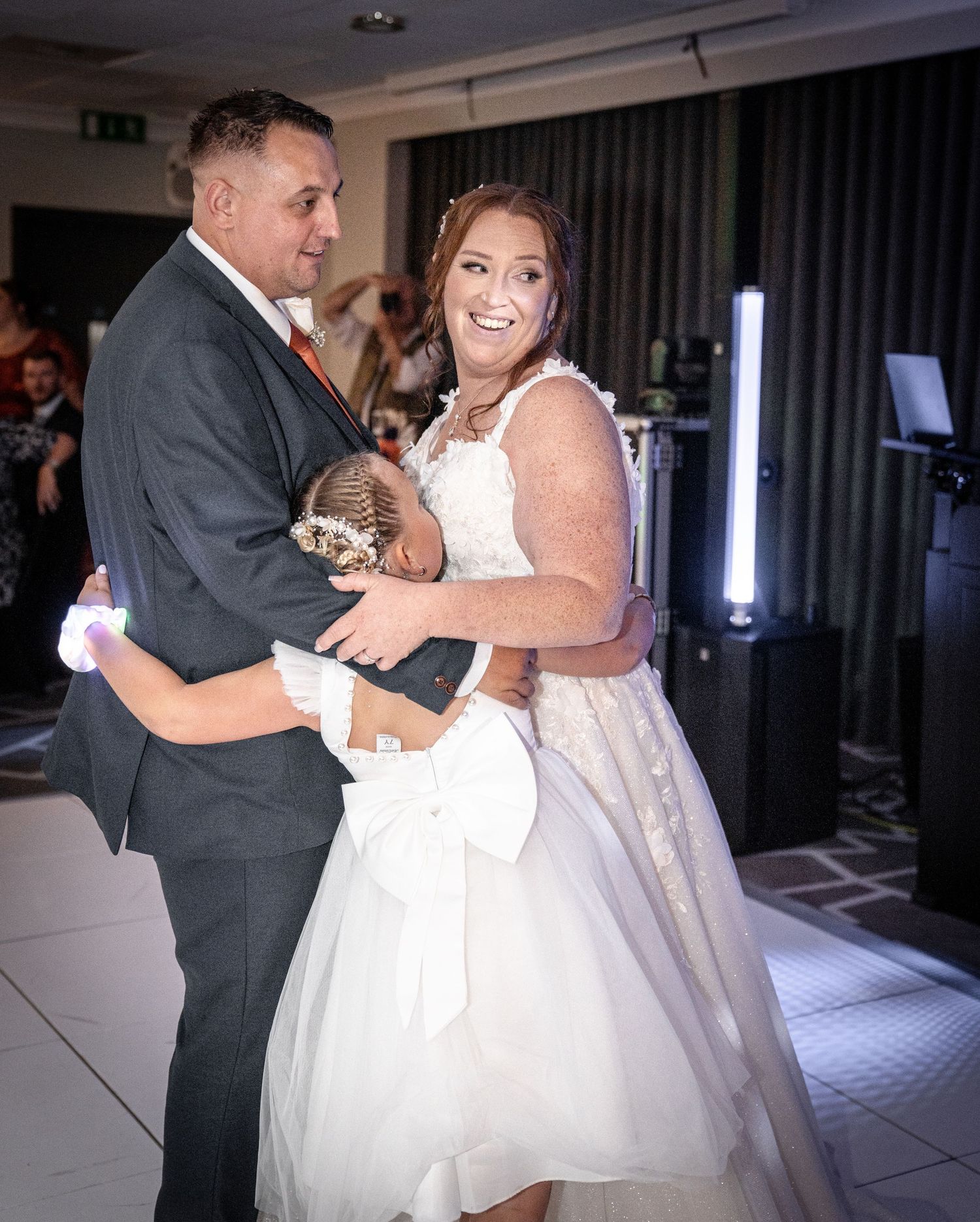 Dance floor moments during a wedding reception showing emotional embraces.