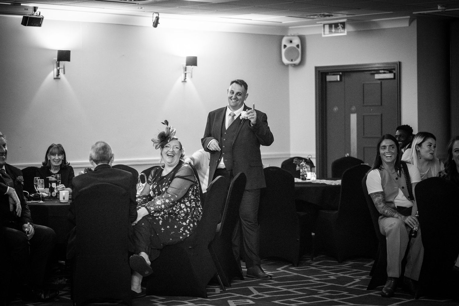 Professional gathering in conference room setting with attendees participating in group discussions and presentations.
