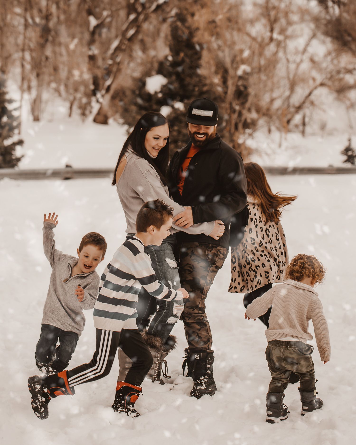 A group plays together in the snow, throwing snowballs and enjoying winter fun in a sepia-toned photo series.