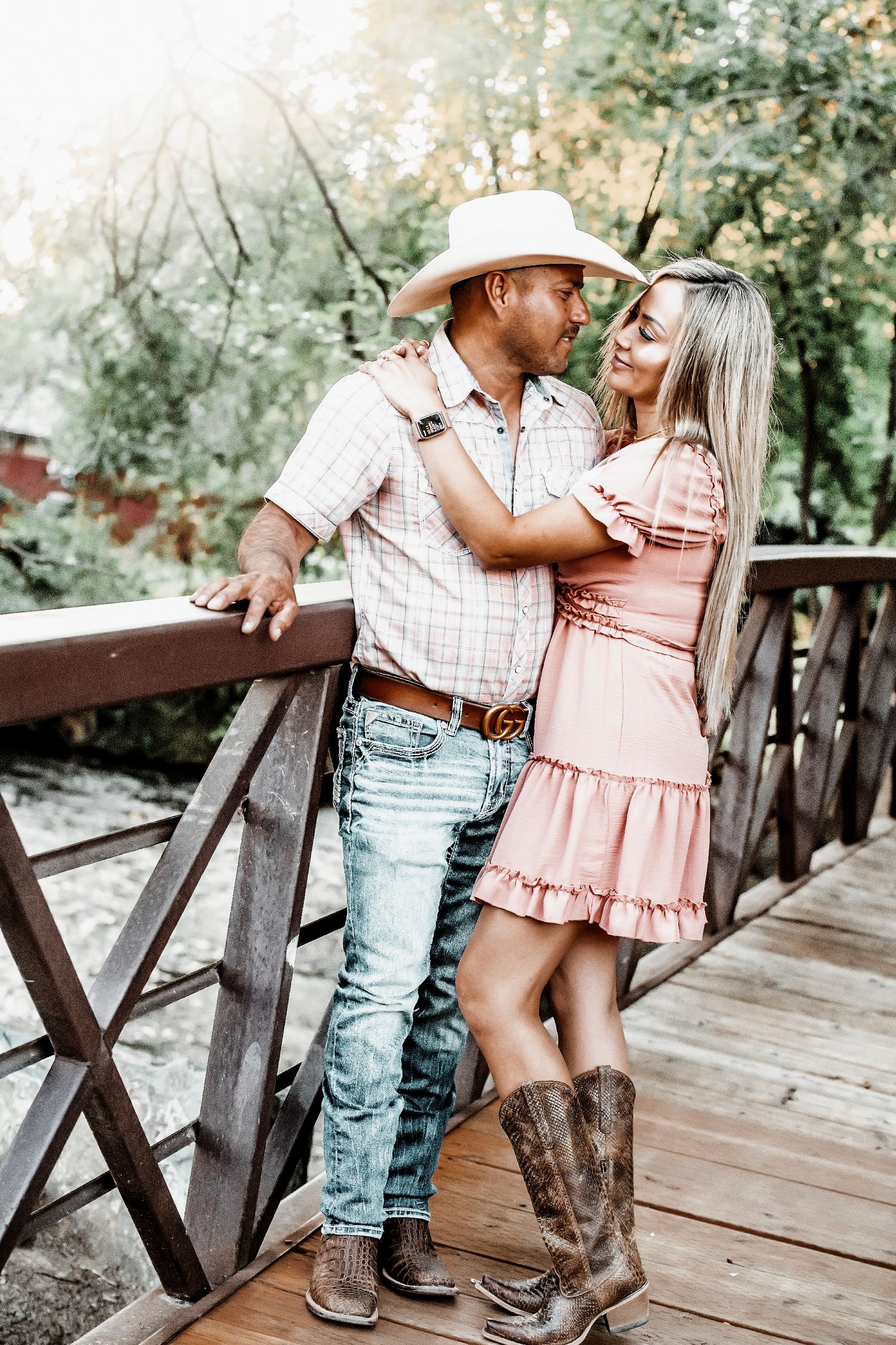 A couple in western attire share romantic moments on a wooden bridge in a series of four connected photos.