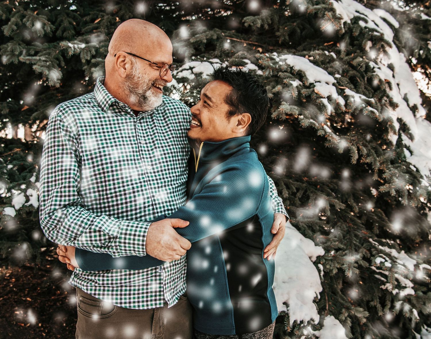 A couple shares tender moments in a winter setting with snow falling around them.