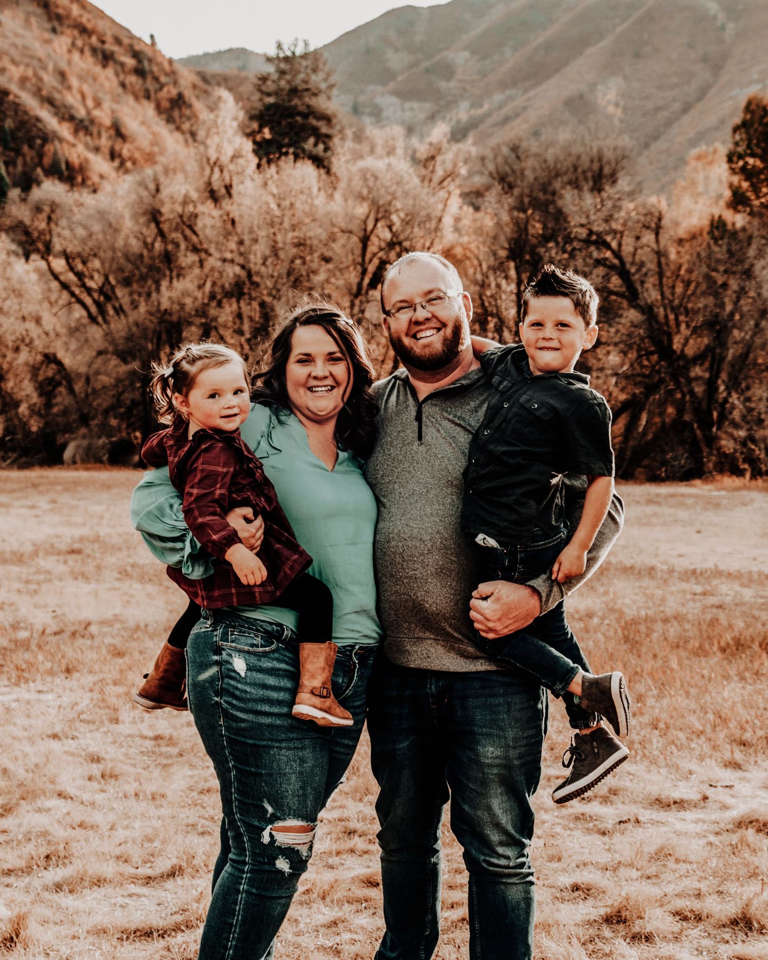 Family enjoying a warm autumn day together outdoors with mountains in the background.