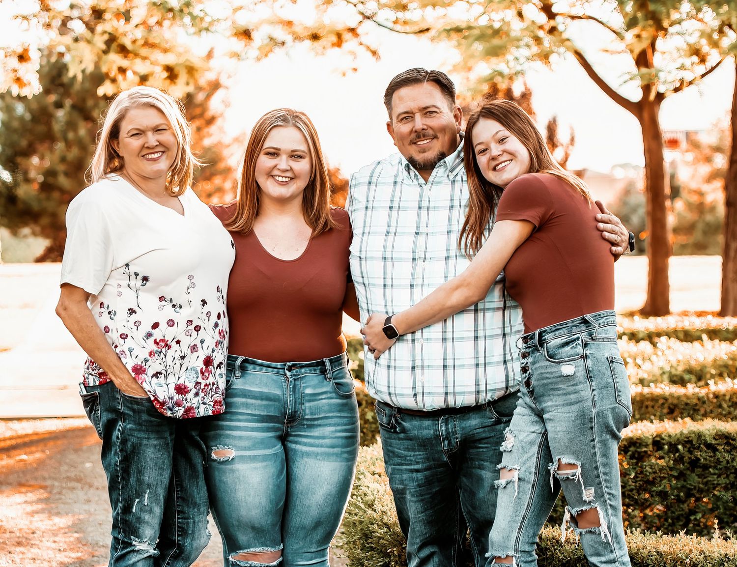 A series of warm-toned outdoor family portraits taken at sunset with matching brown and white outfits.