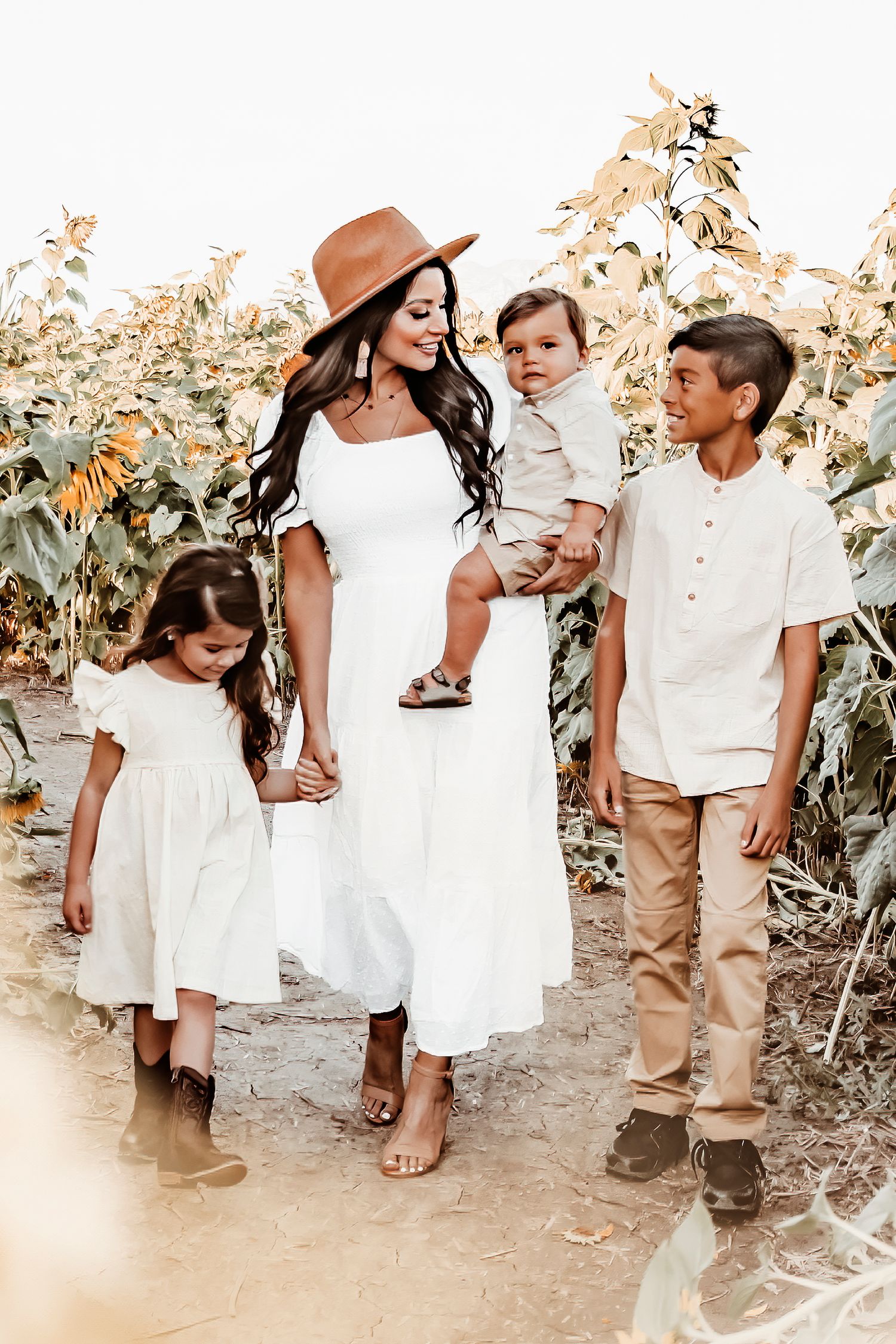 A series of candid family photos showing people in white dresses and brown clothing interacting outdoors in a sunlit setting.