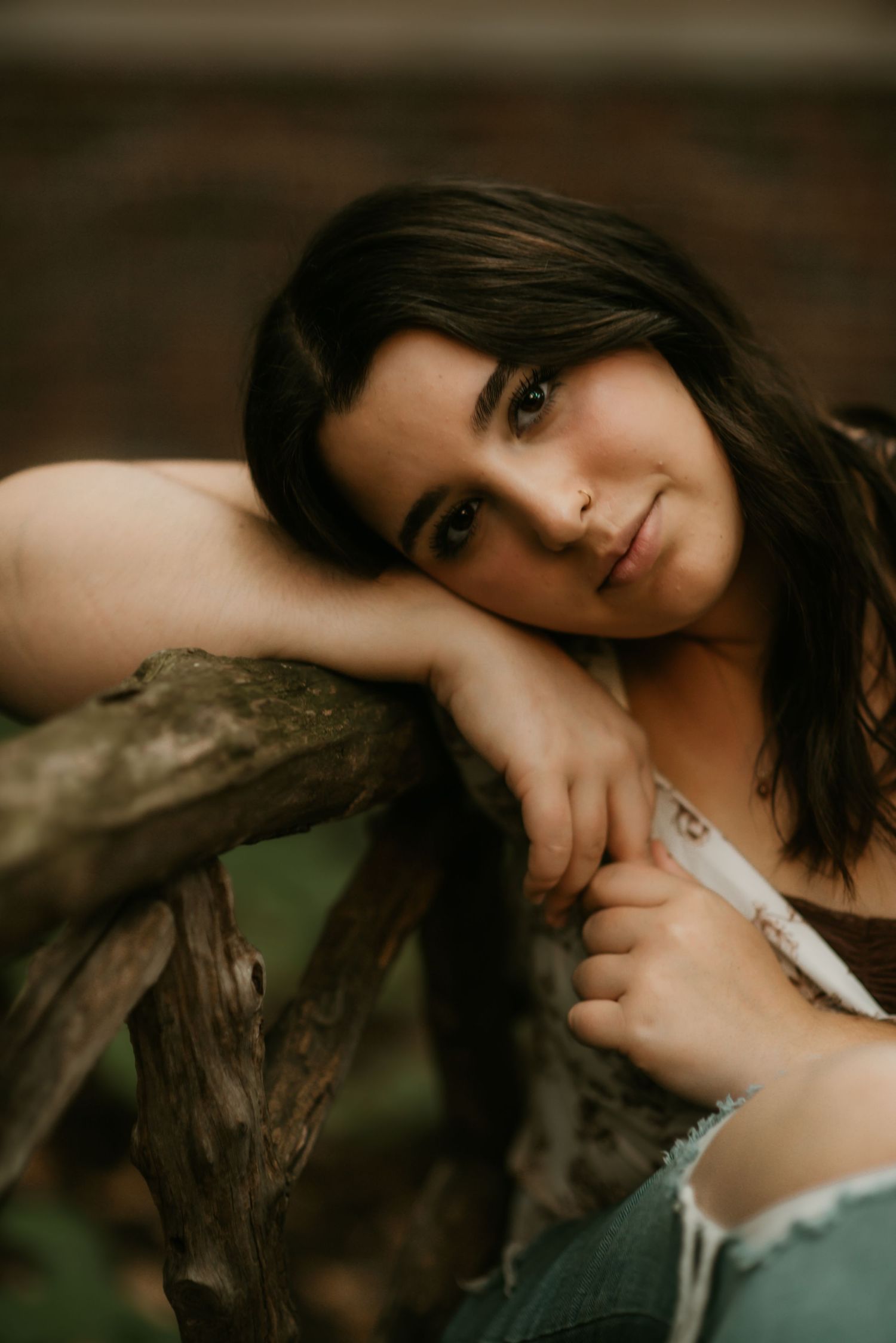 A series of moody portrait photographs in sepia tones showing someone posing against a dark background.