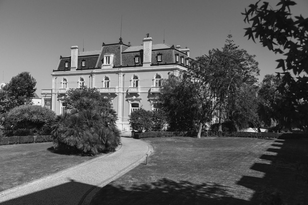 Six sequential views show a grand manor or estate house on a hill, captured in black and white photography.