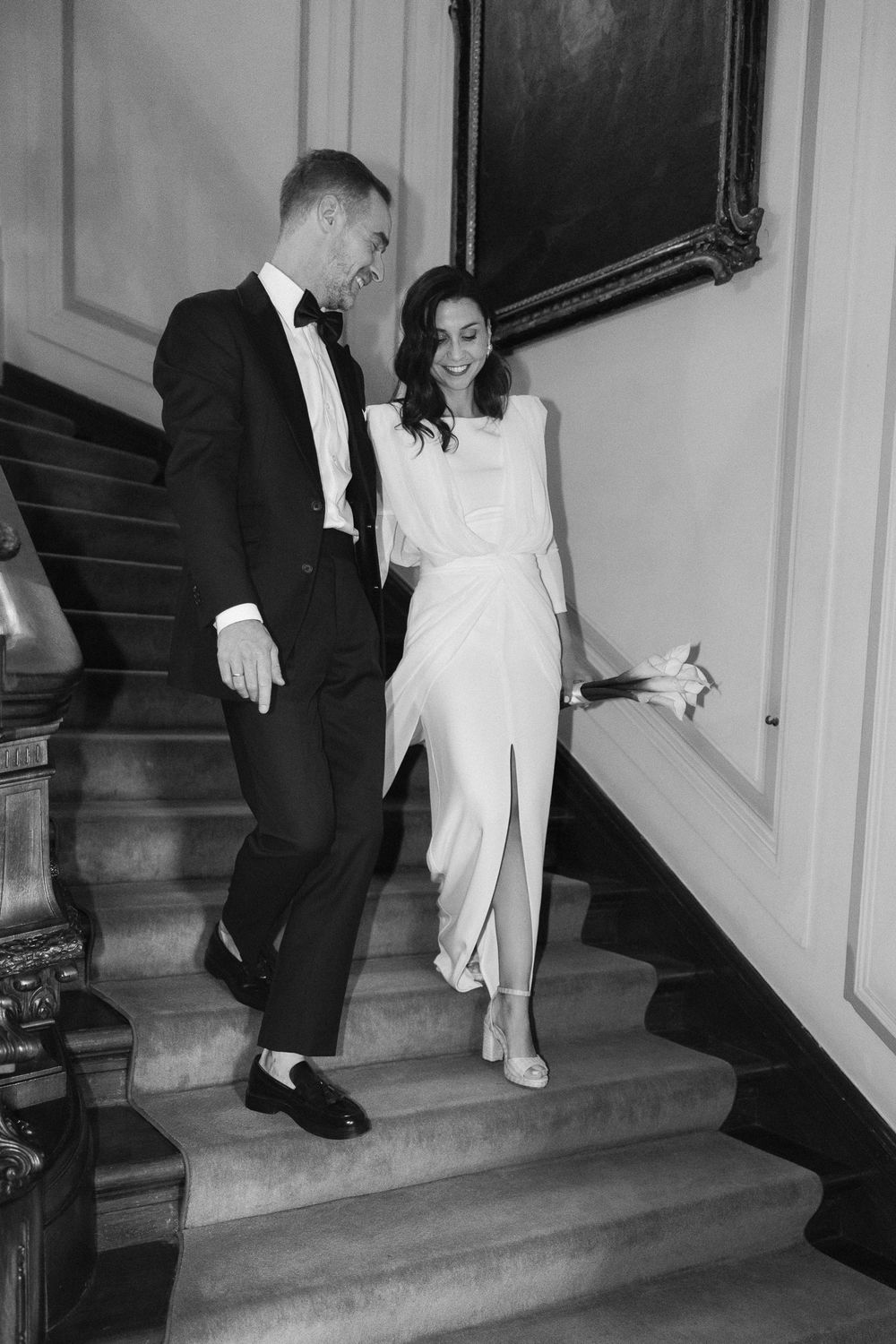 A sequence of black and white photos showing elegant couple descending stairs in formal attire at an event.
