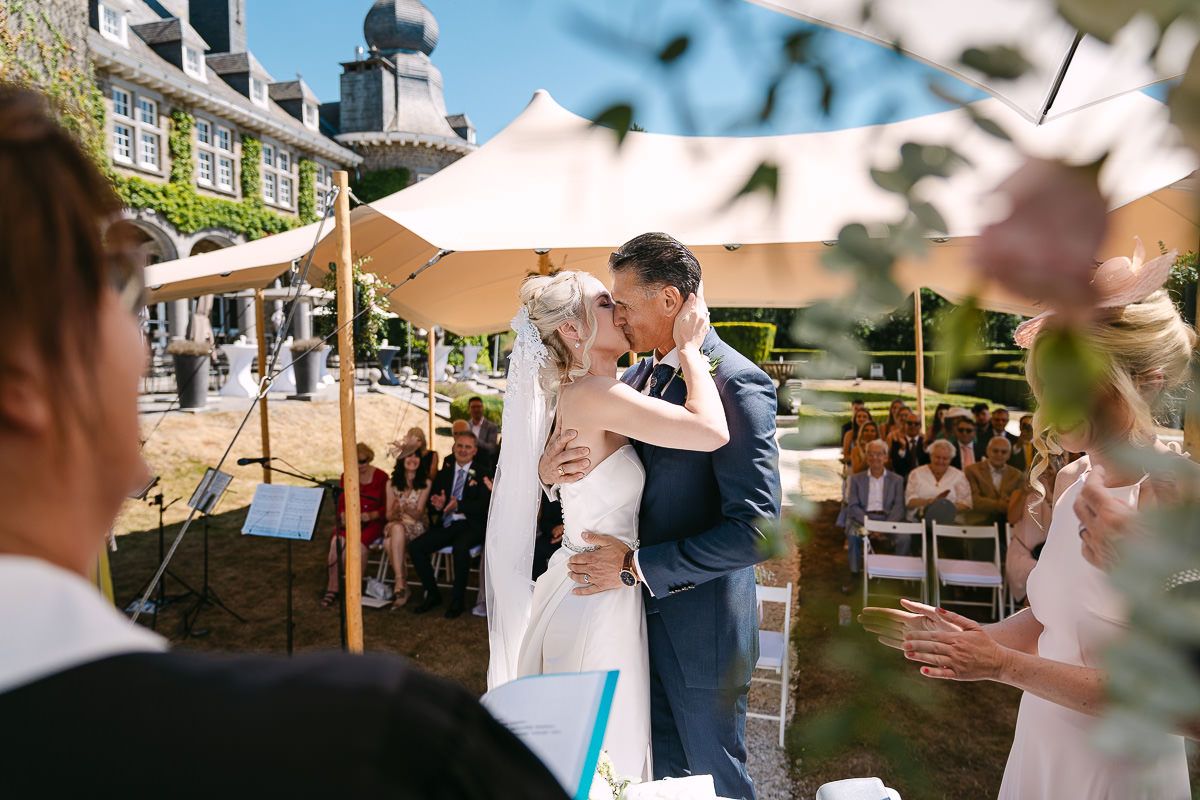 First kiss of bride and groom at Manoir de Lébioles ceremony