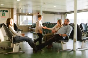 People relaxing in modern white lounge chairs inside a bright contemporary waiting area.