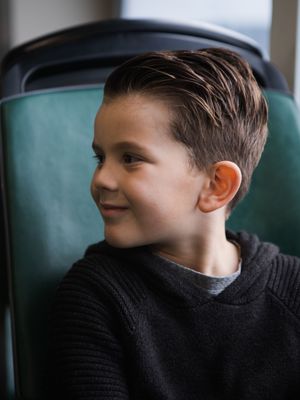 A series of four profile shots showing someone in a black sweater looking to the right against a teal background.