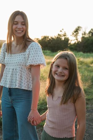 Two people in casual summer outfits sharing a happy moment together outdoors during golden hour sunset.