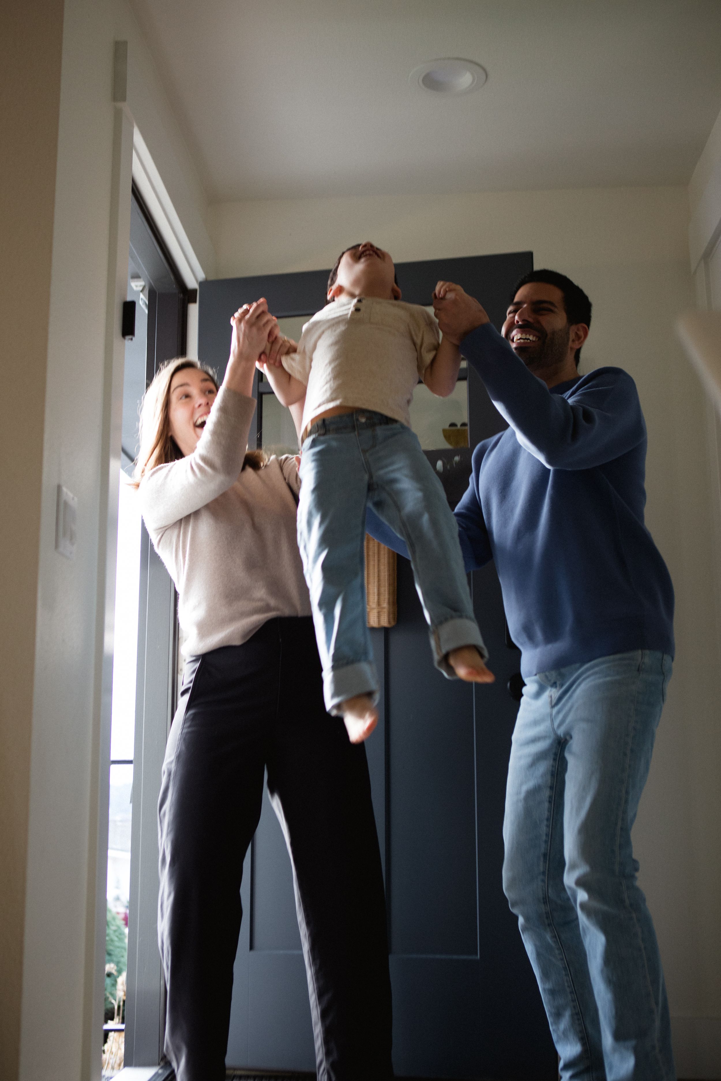 A group of people jumping and dancing in a hallway wearing casual clothing and expressing joyful energy.