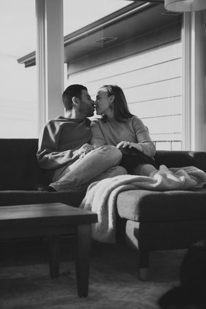 A series of black and white photographs showing two people lying down and embracing on a couch.