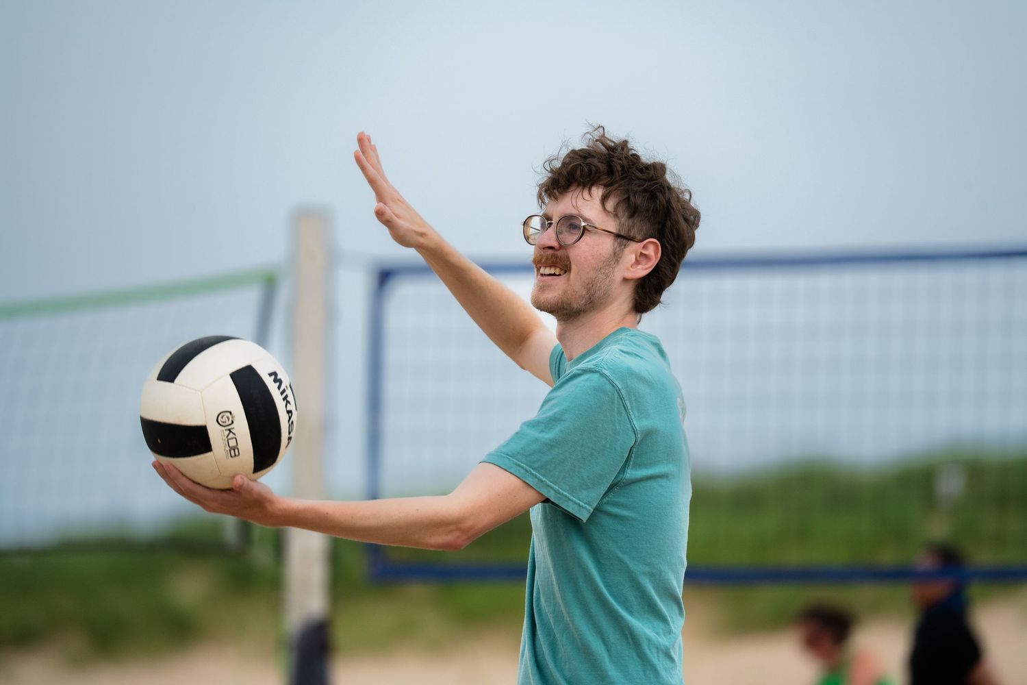 A volleyball athlete prepares to serve the ball to start the point on the beach in Chicago