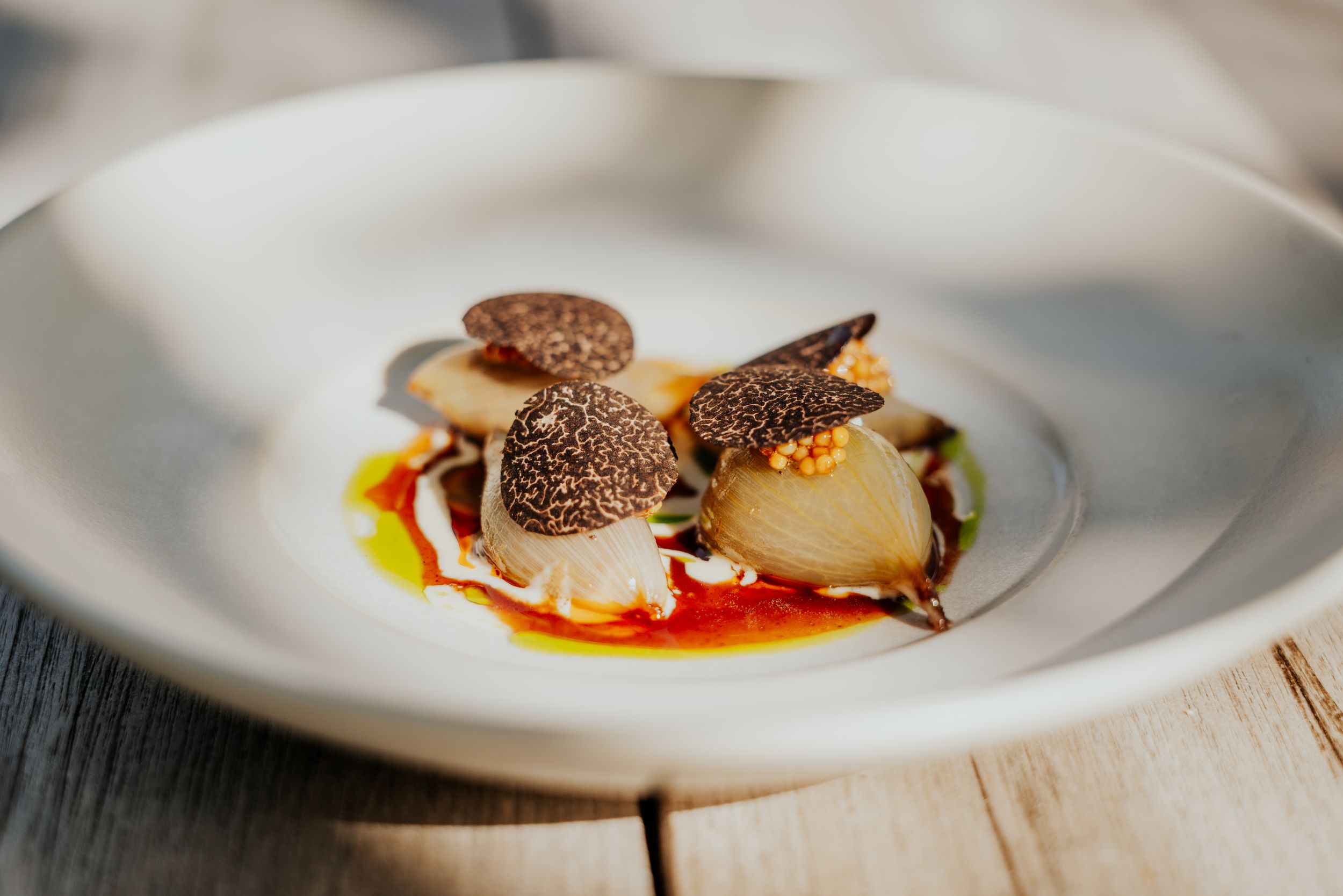Artfully plated fine dining dish with garnishes on a white plate.