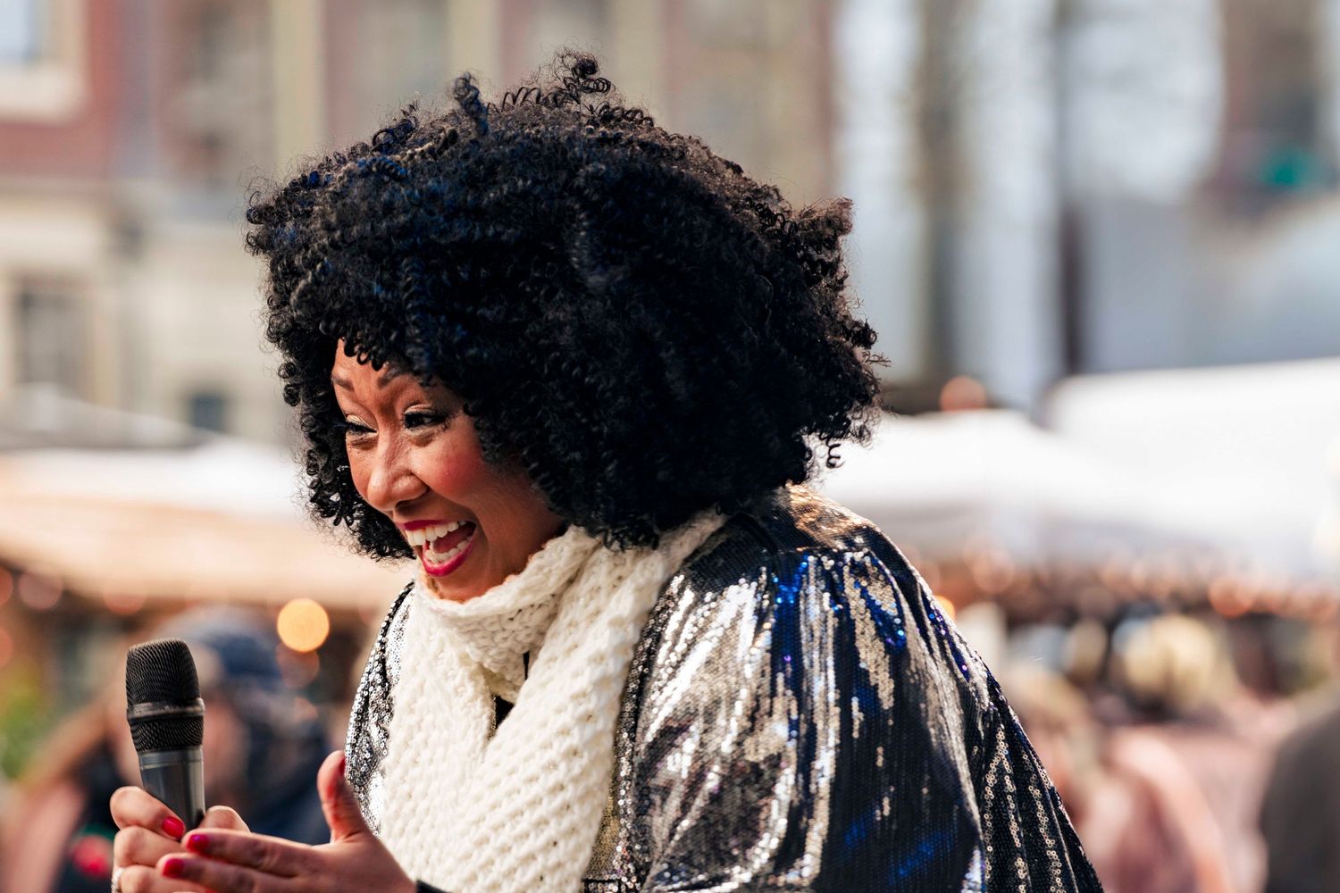 Performer with microphone singing passionately at an outdoor event.