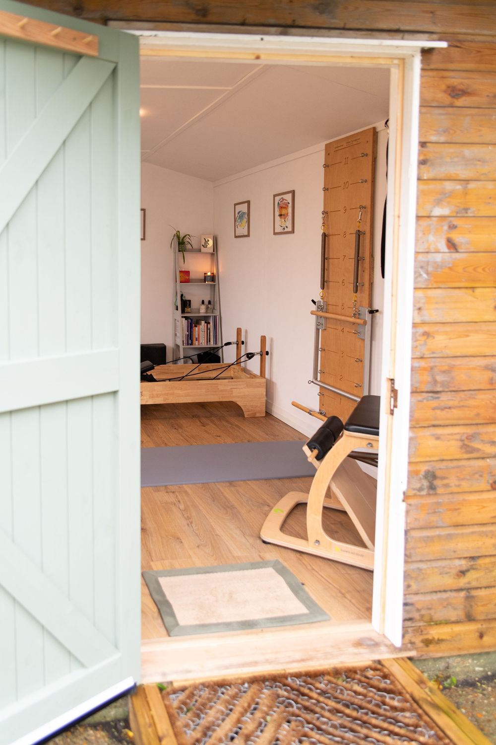 Sequence of images showing a wooden door opening to reveal a home gym space with exercise equipment and natural lighting.